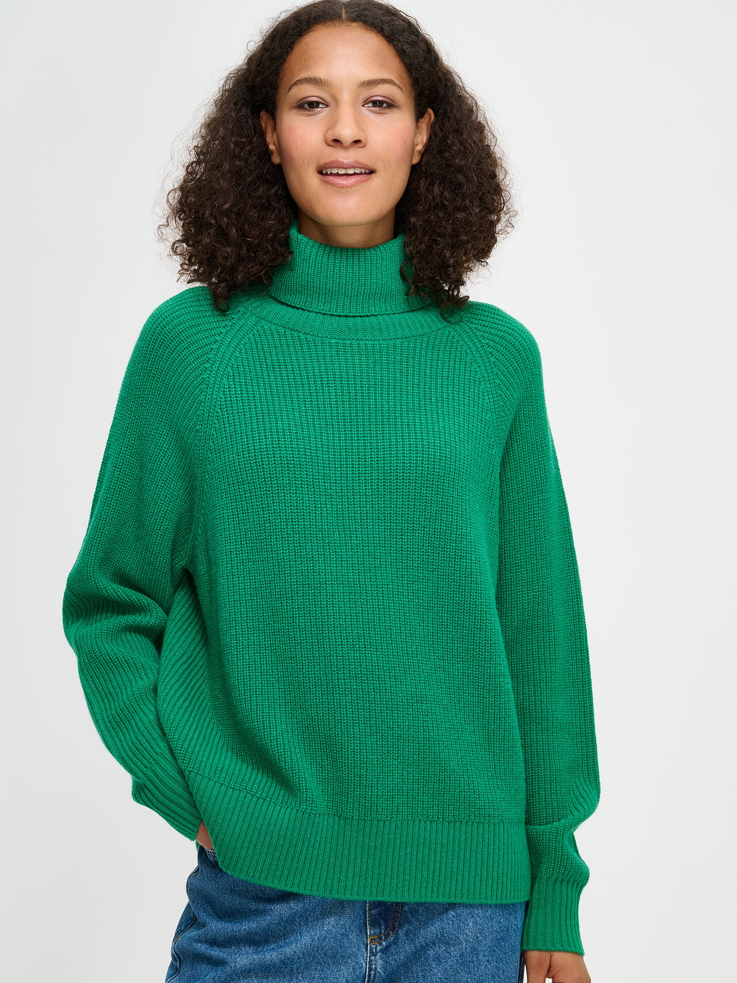 Nanso's Pamela sweater for women is a cozy, green knit featuring a turtleneck and full-length raglan sleeves, size S close-up