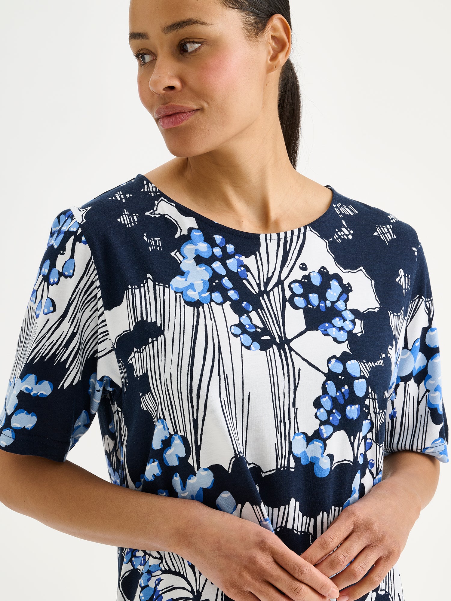 Nanso KIRJOKERTTU Long Nightgown, featuring an elegant blue nature-inspired print on a model, close-up.