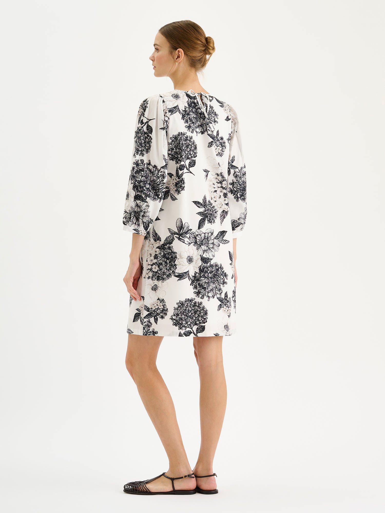 Nanso Palatsi Dress in a striking black and white floral pattern on a model, pictured from the backside