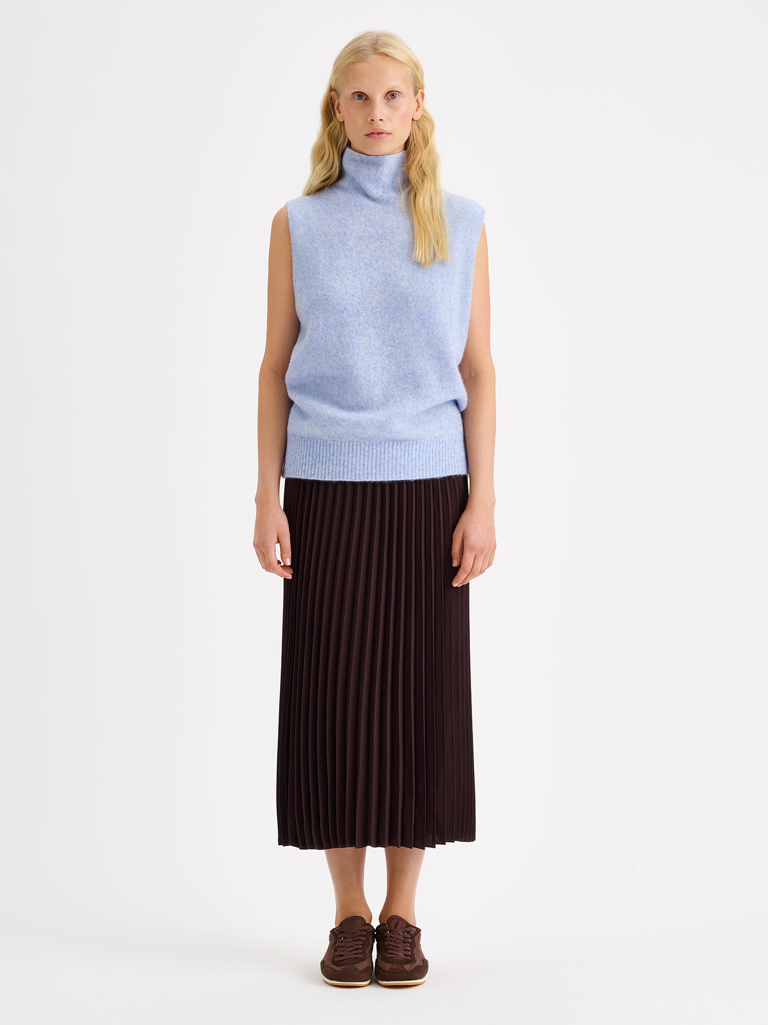 Nanso elegant midi length ARIEL Skirt in a trendy brown shade on a model with a light blue sleeveless knit vest
