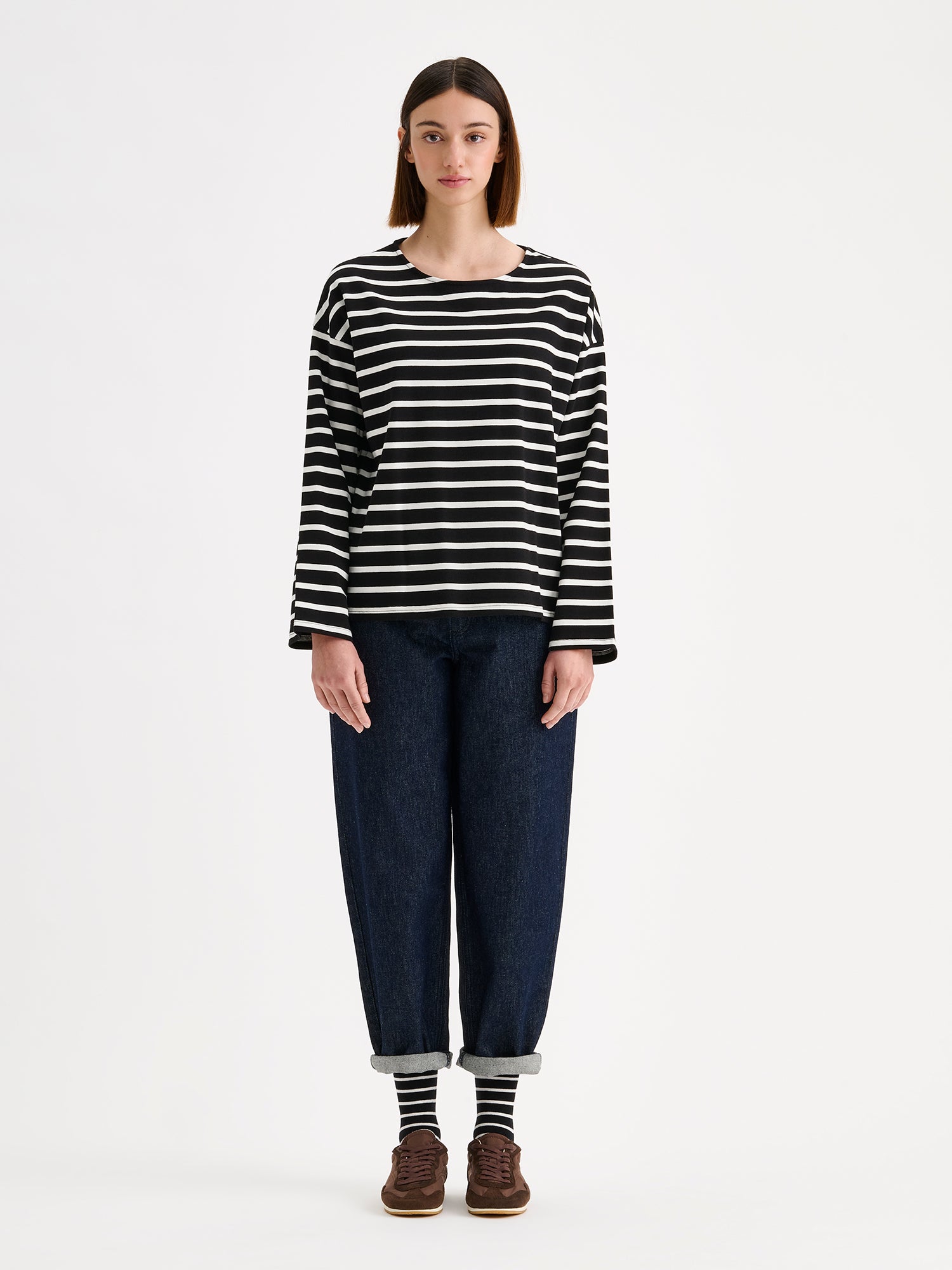 Nanso women's black and white striped long-sleeved Breton blouse with a relaxed, effortless fit, on a model with dark blue jeans.