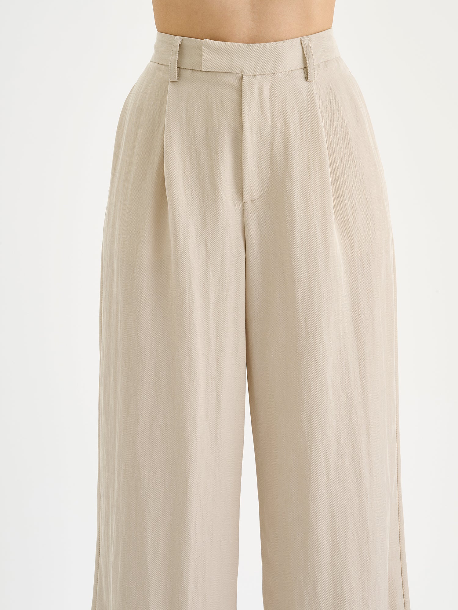 Nanso Nizza trousers in a sophisticated beige shade on a model, close-up.