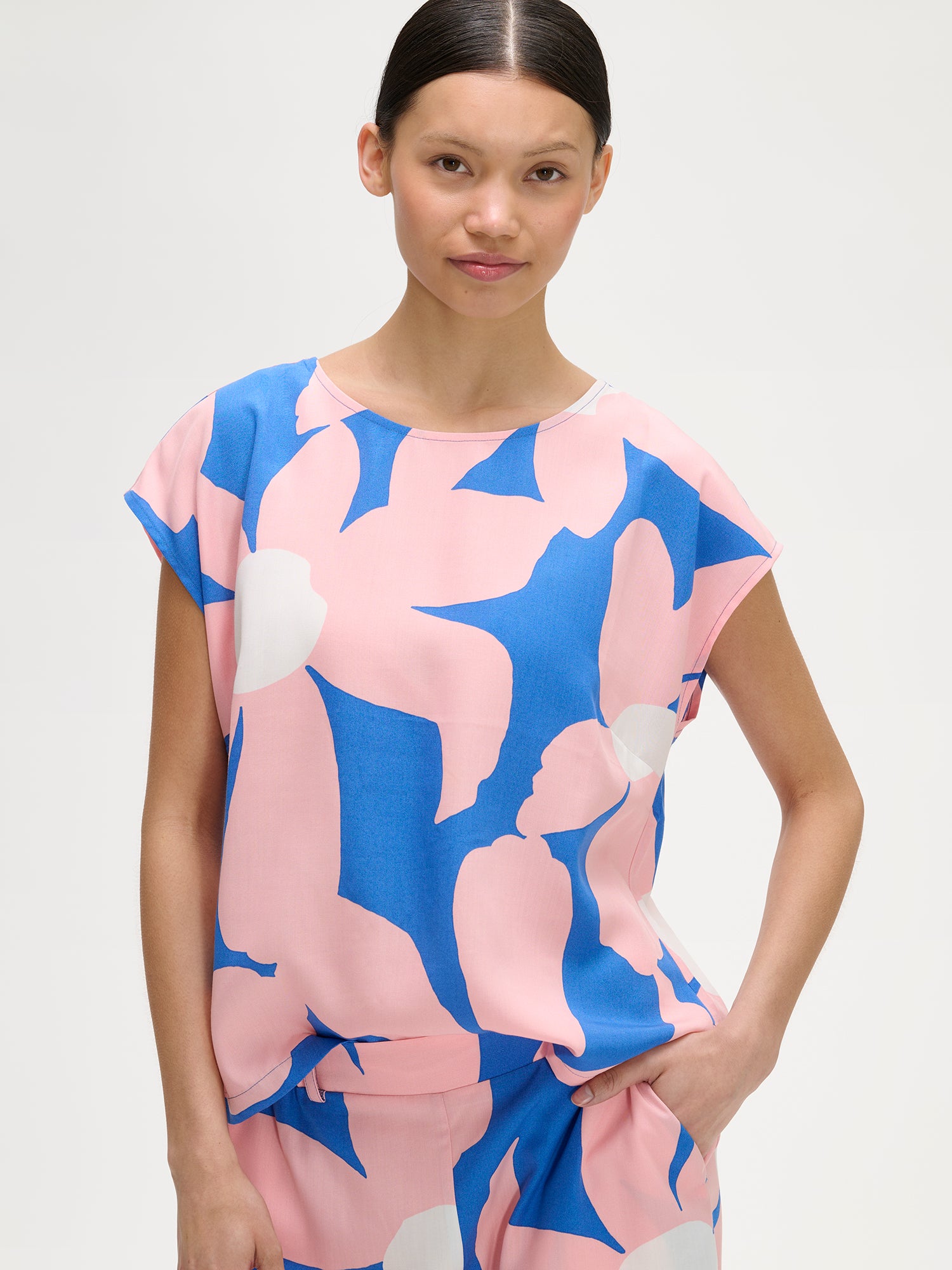 Nanso women's patterned floral ROSI Blouse in pink and blue, on a model with matching trousers.