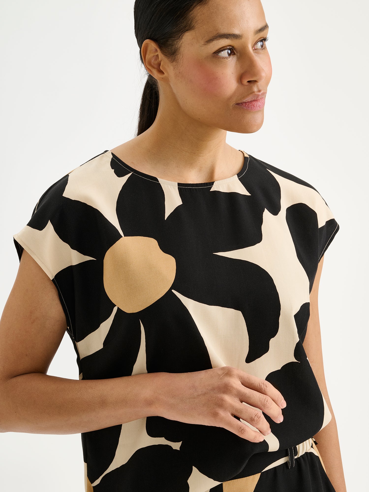 Nanso women's patterned floral ROSI Blouse in black and beige, on a model with matching trousers, close-up.