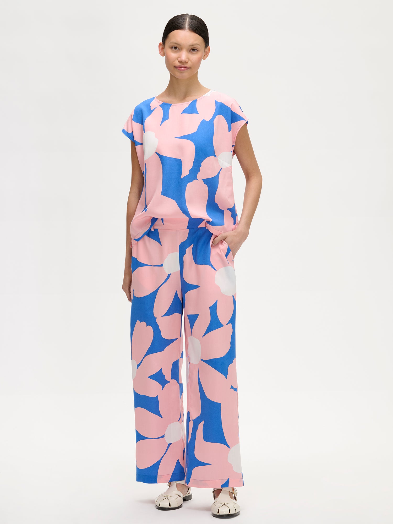 Nanso women's patterned floral ROSI Blouse in pink and blue, on a model with matching trousers.