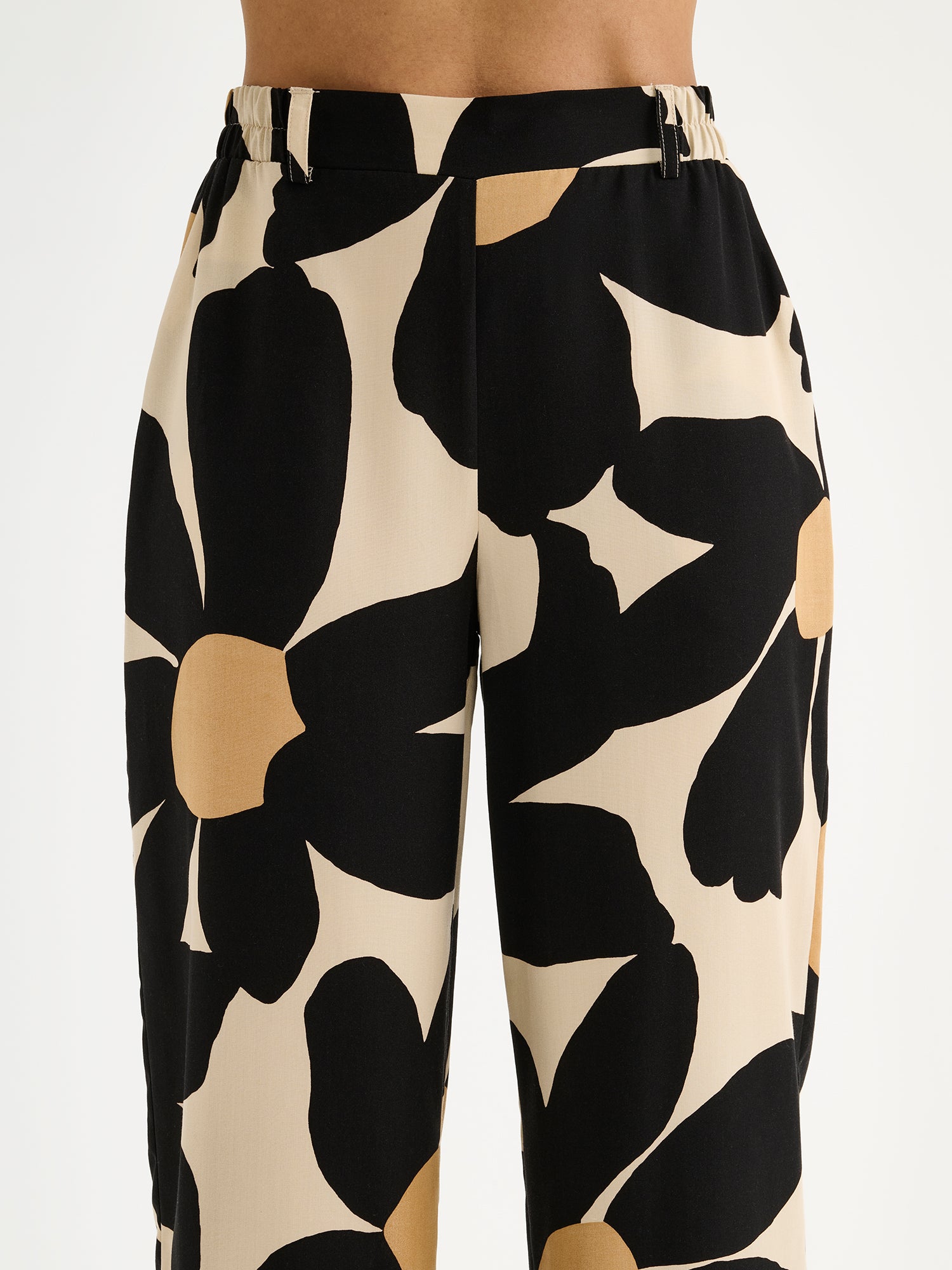 Nanso women's Rosi trousers feature a striking floral pattern and wide fit, pictured on a model, close-up.
