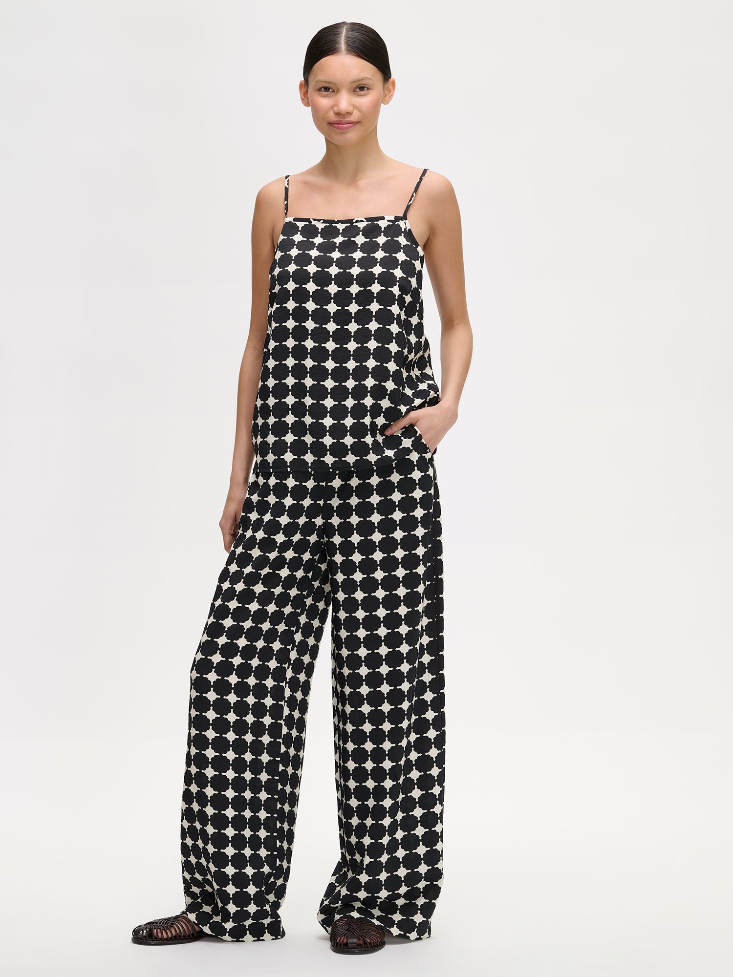 Nanso women's patterned black and white Avene woven top with adjustable spaghetti straps, on a model with matching trousers.