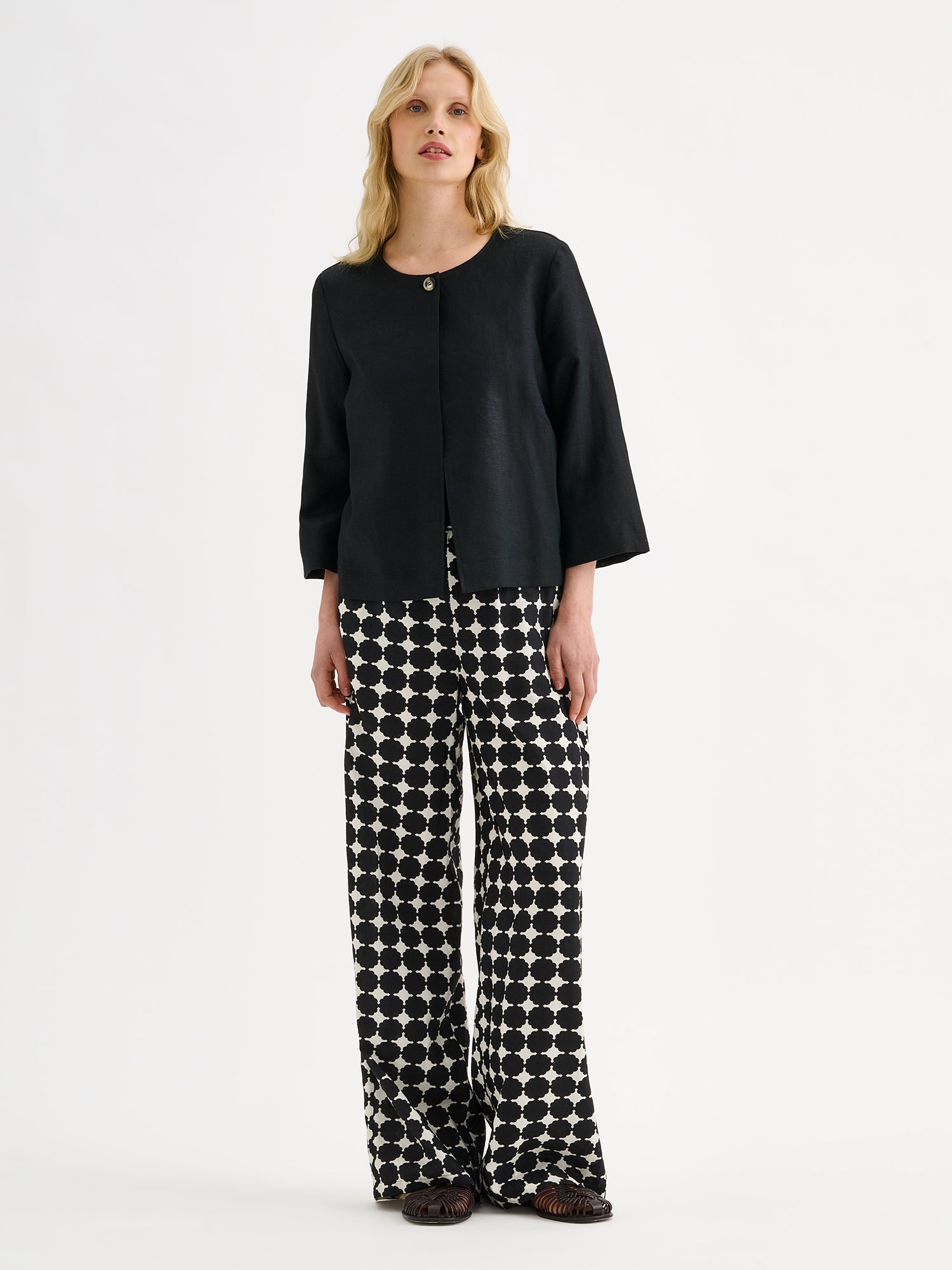 Nanso women's wide-leg Avene trousers in a stylish black and white pattern, on a model with a black linen blazer