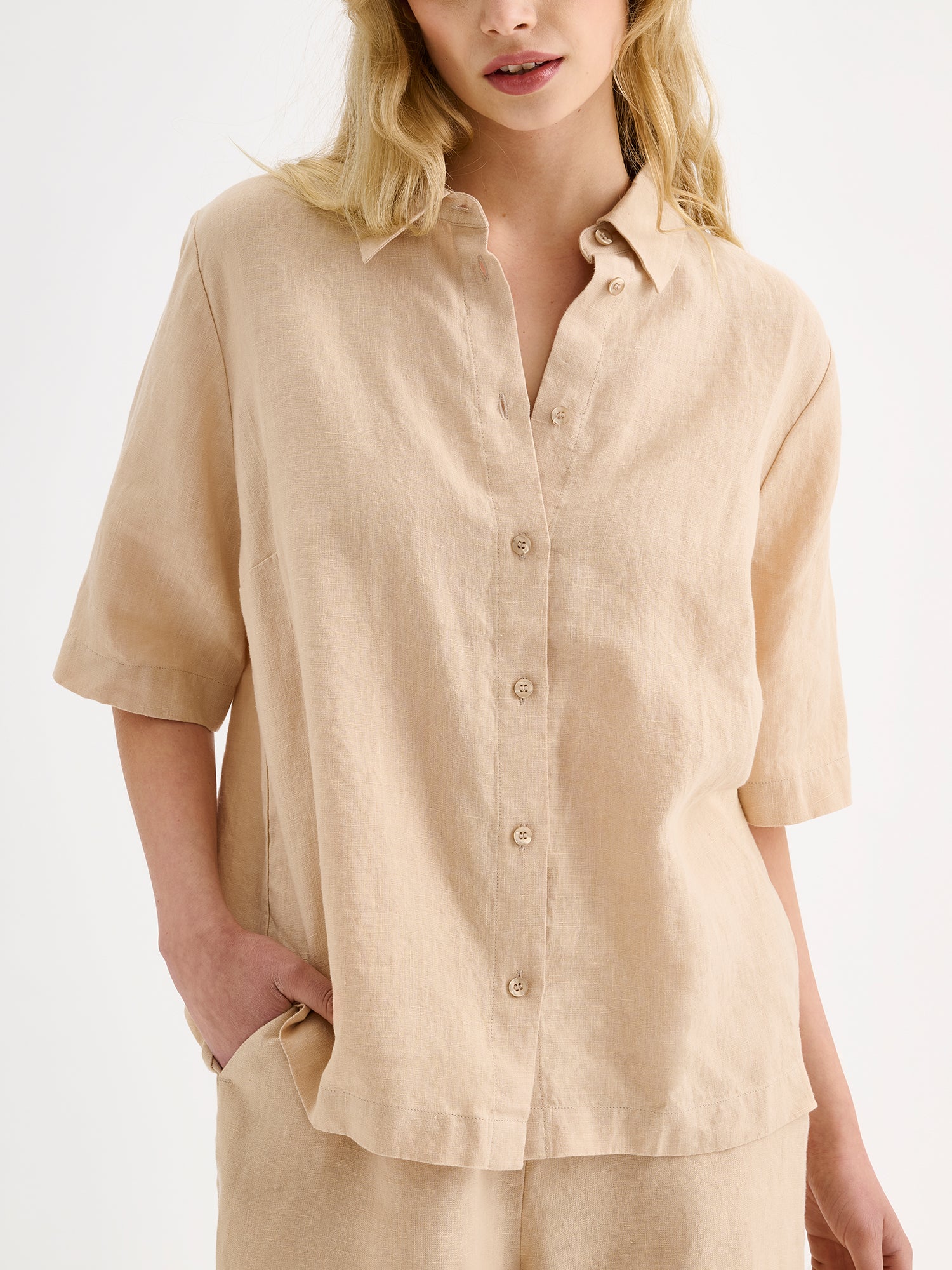 Nanso women's relaxed beige Liine linen shirt, crafted from breathable linen on a model with matching shorts, close-up.