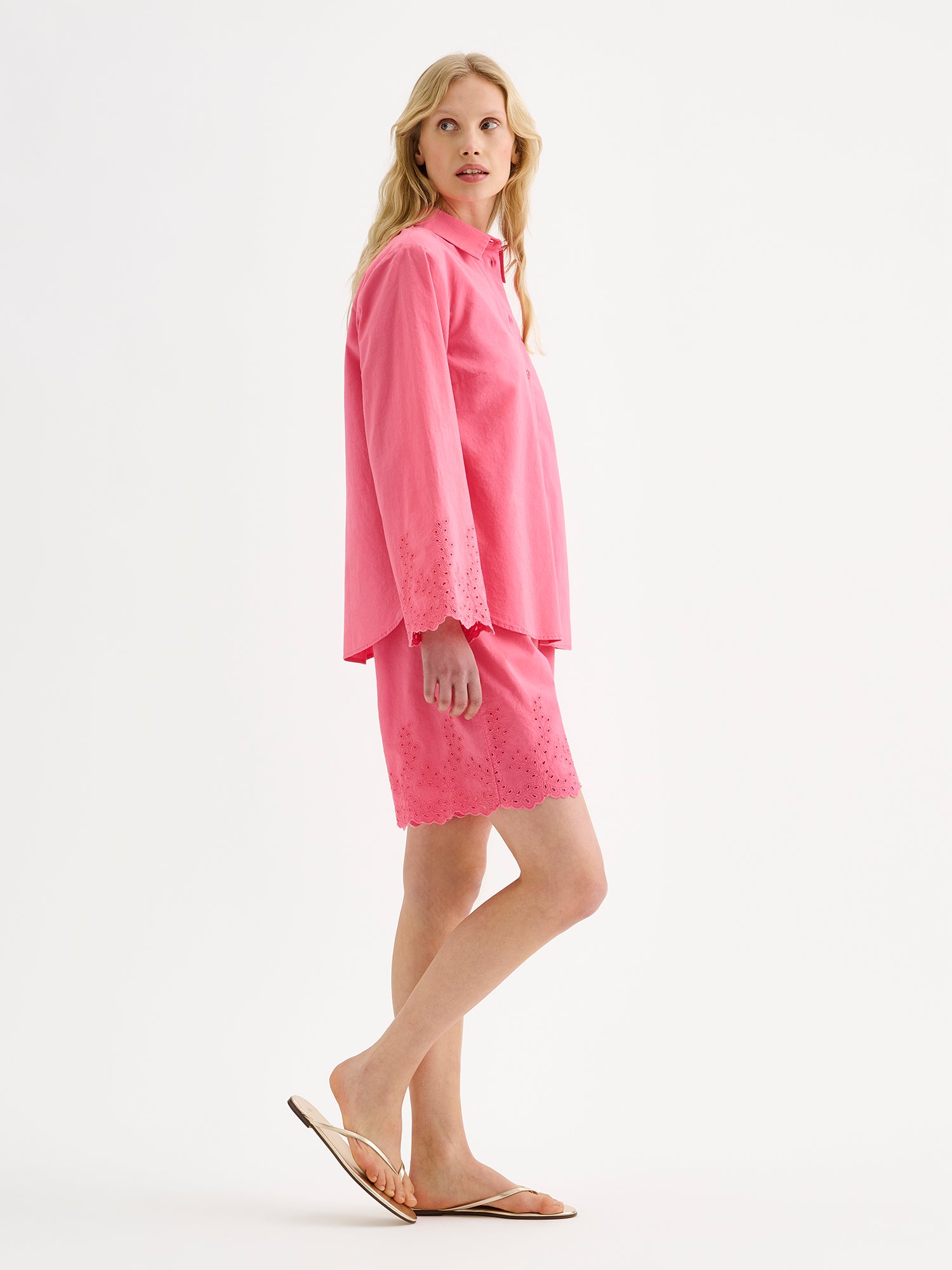 Nanso women's pink Sevilla shorts with lace details on a model with a matching shirt on, pictured from the side angle.