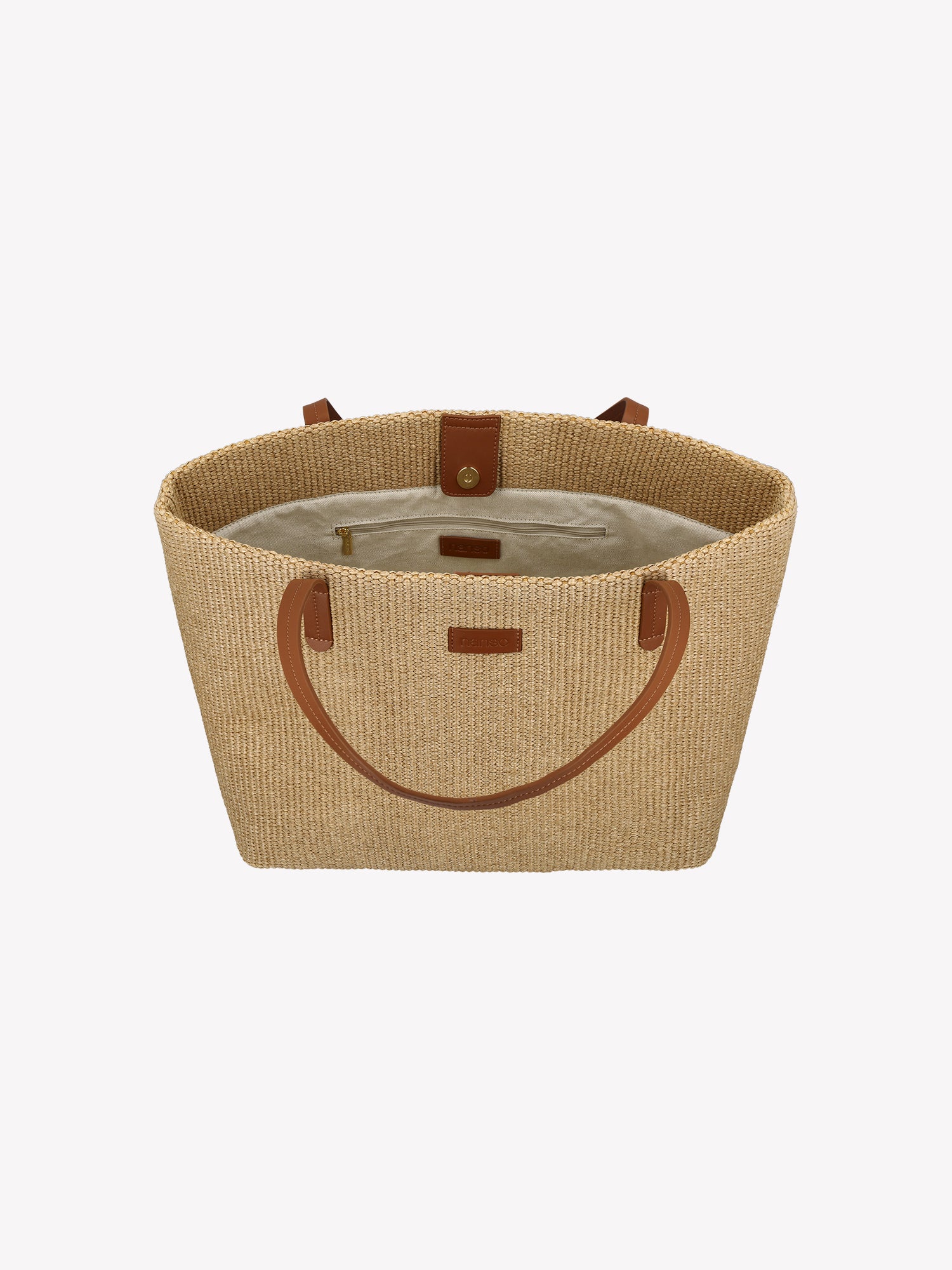 Crafted from durable straw-like material with genuine leather handles, the KORI TOTE Bag combines natural texture with refined style. The KORI TOTE features a cotton lining. Product picture from the and slightly above.