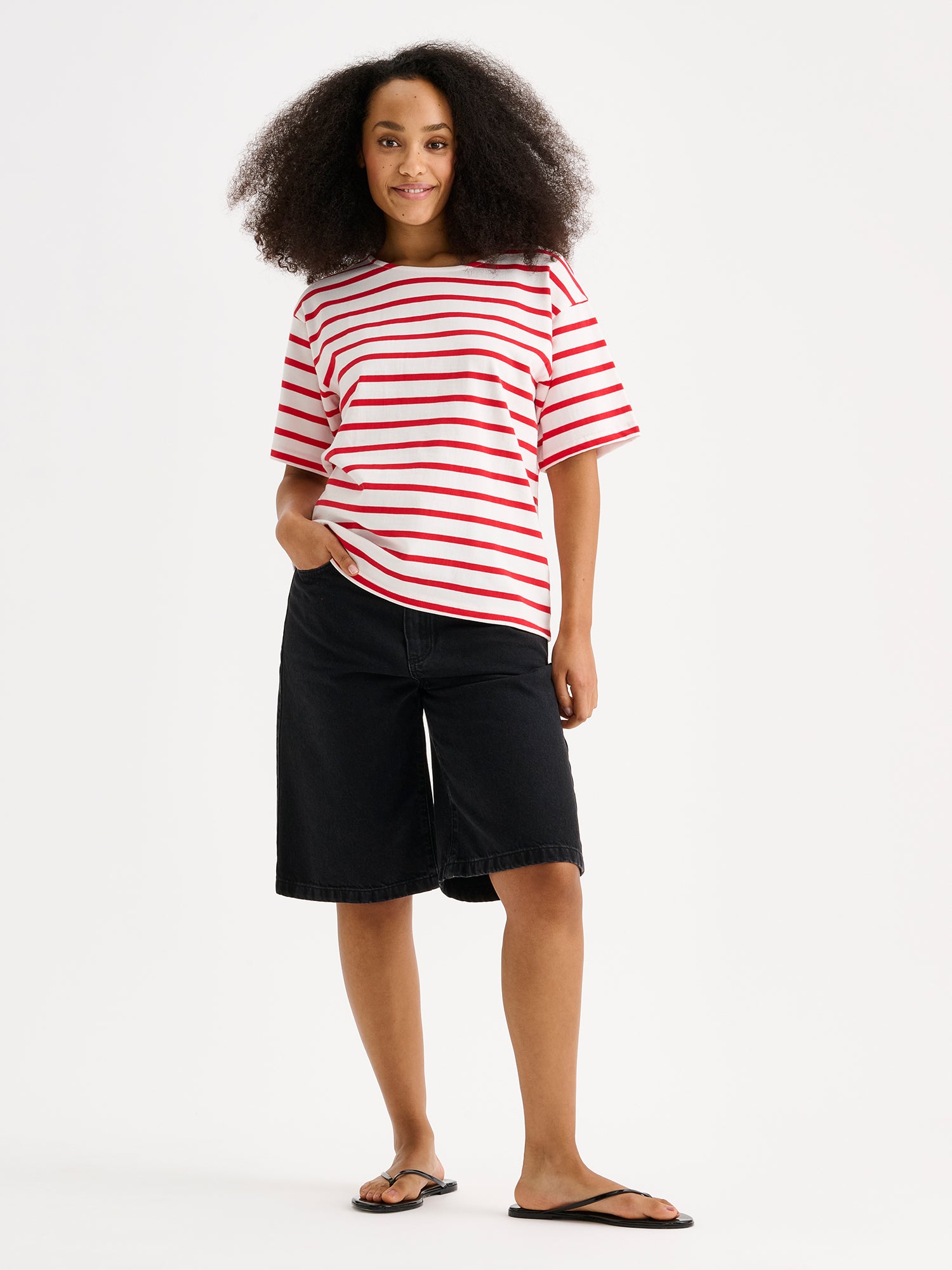 Nanso timeless red and white striped short-sleeved Breton T-shirt on a model with shorts and flip flops.