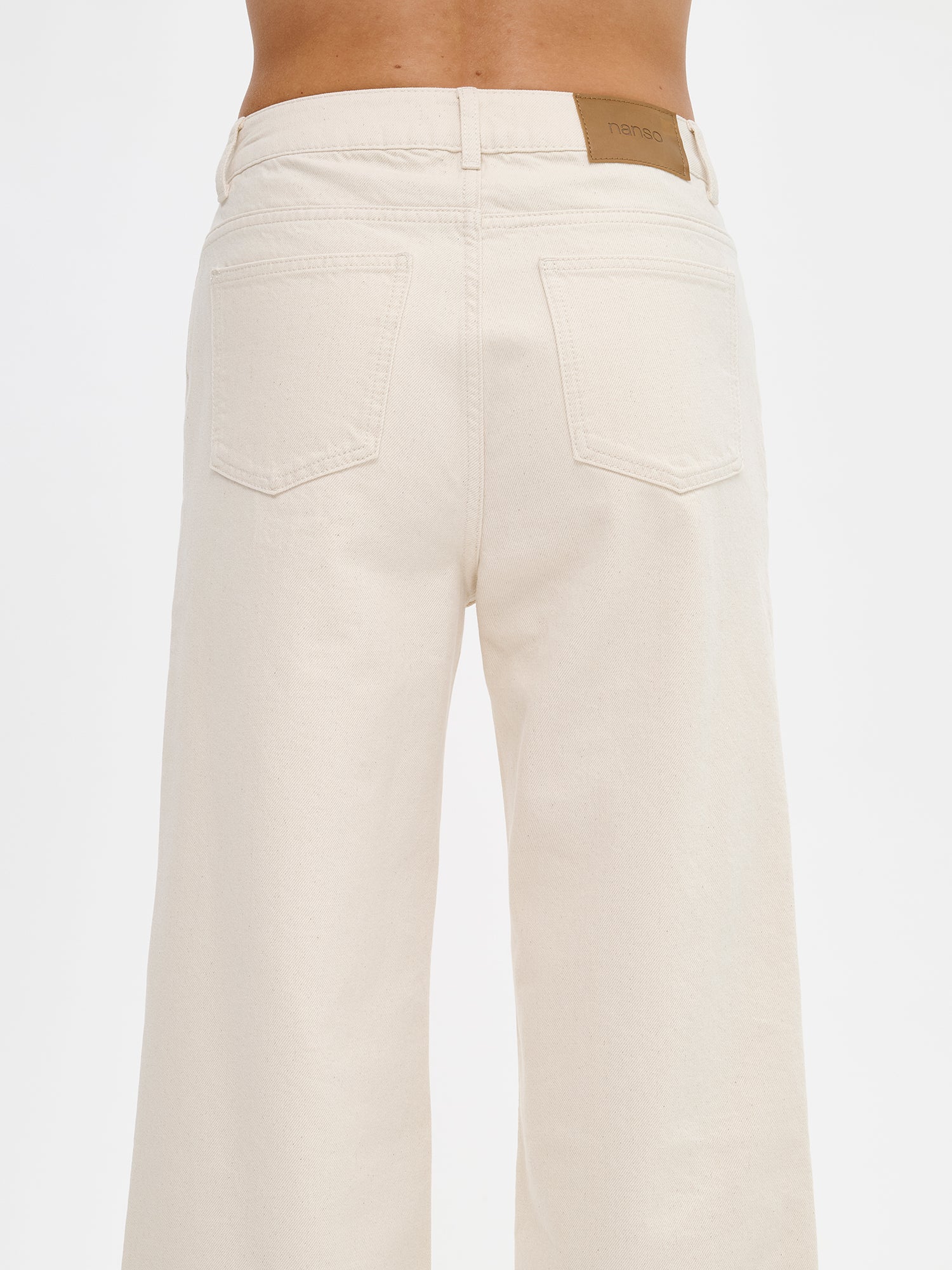 Nanso women’s trendy off white Cropped Levee jeans with a high waist, on a model from the back.