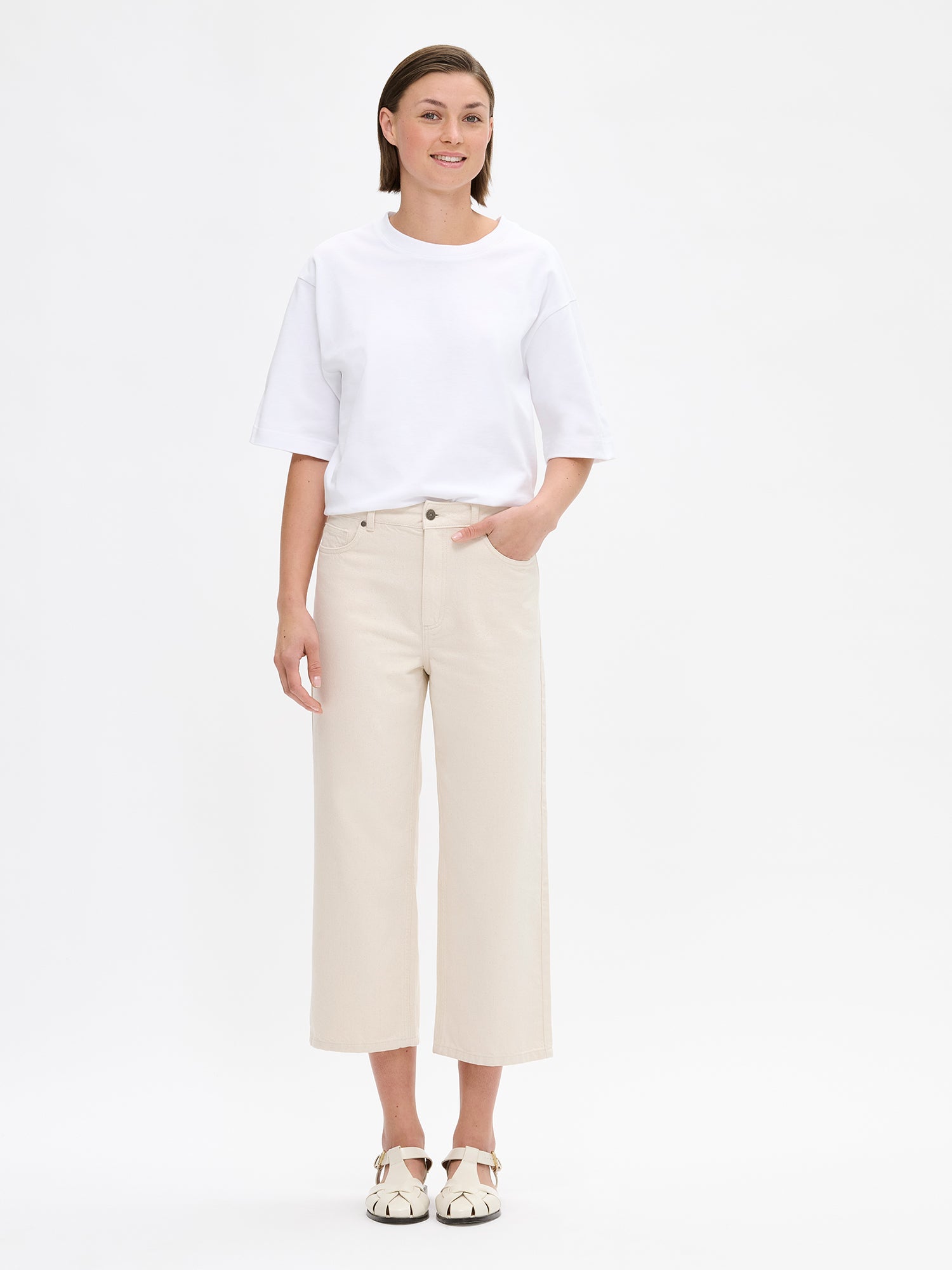 Nanso women’s trendy off white Cropped Levee jeans with a high waist, on a model from the front.