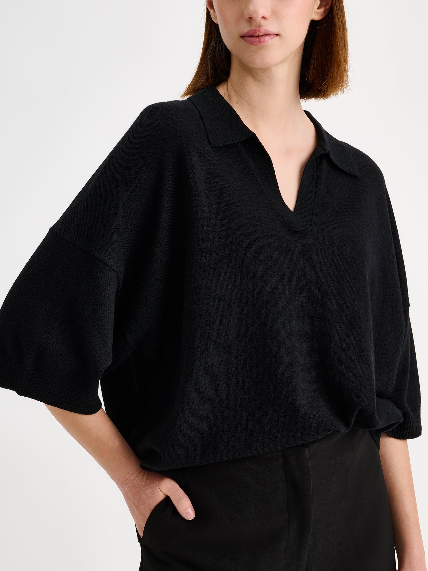Nanso women's black, timeless Villis knit sweater with collar details, on a model with black trousers