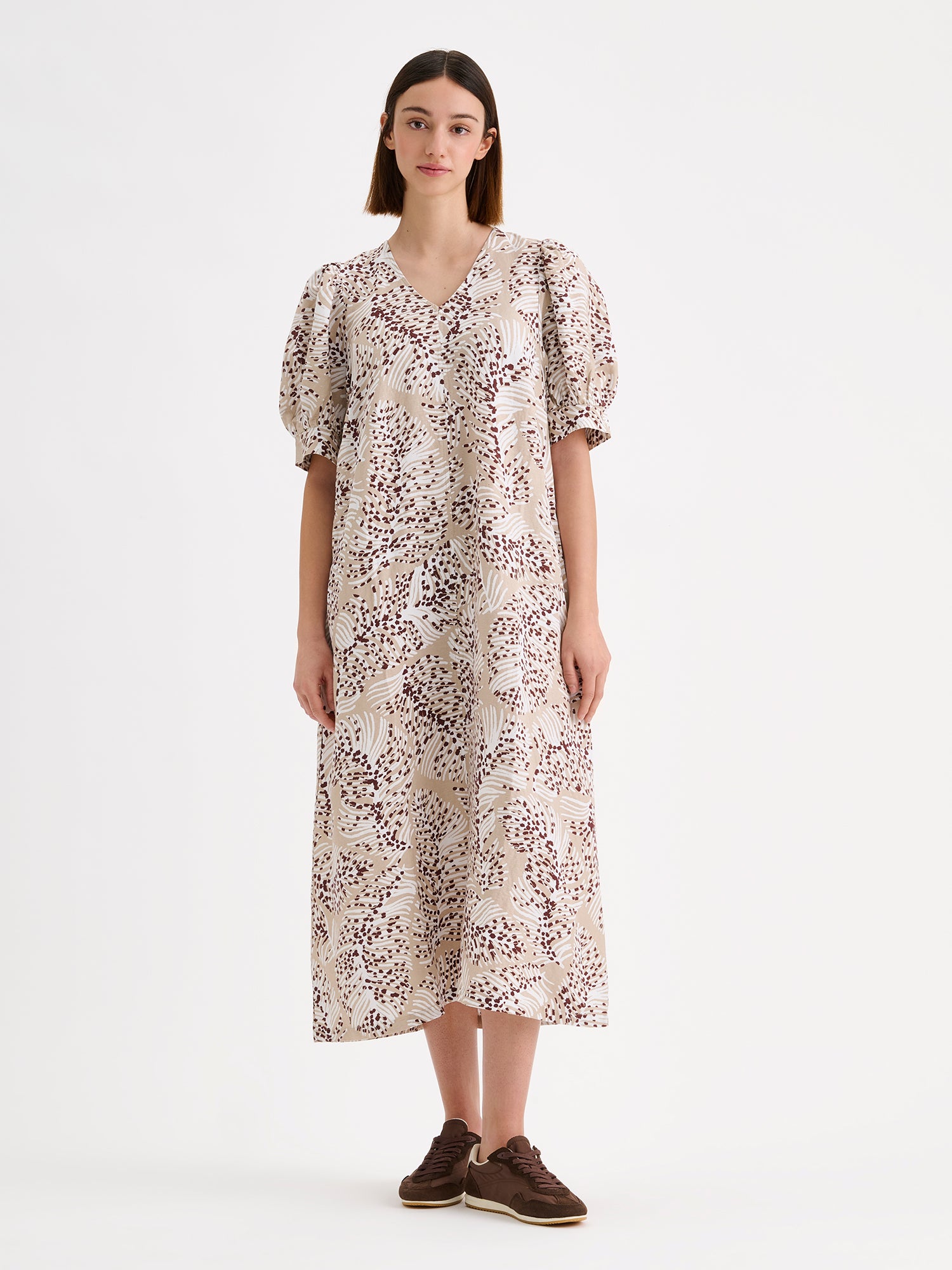 Nanso women's midi Hilde dress in a stylish and delicate beige print on a model with sneakers