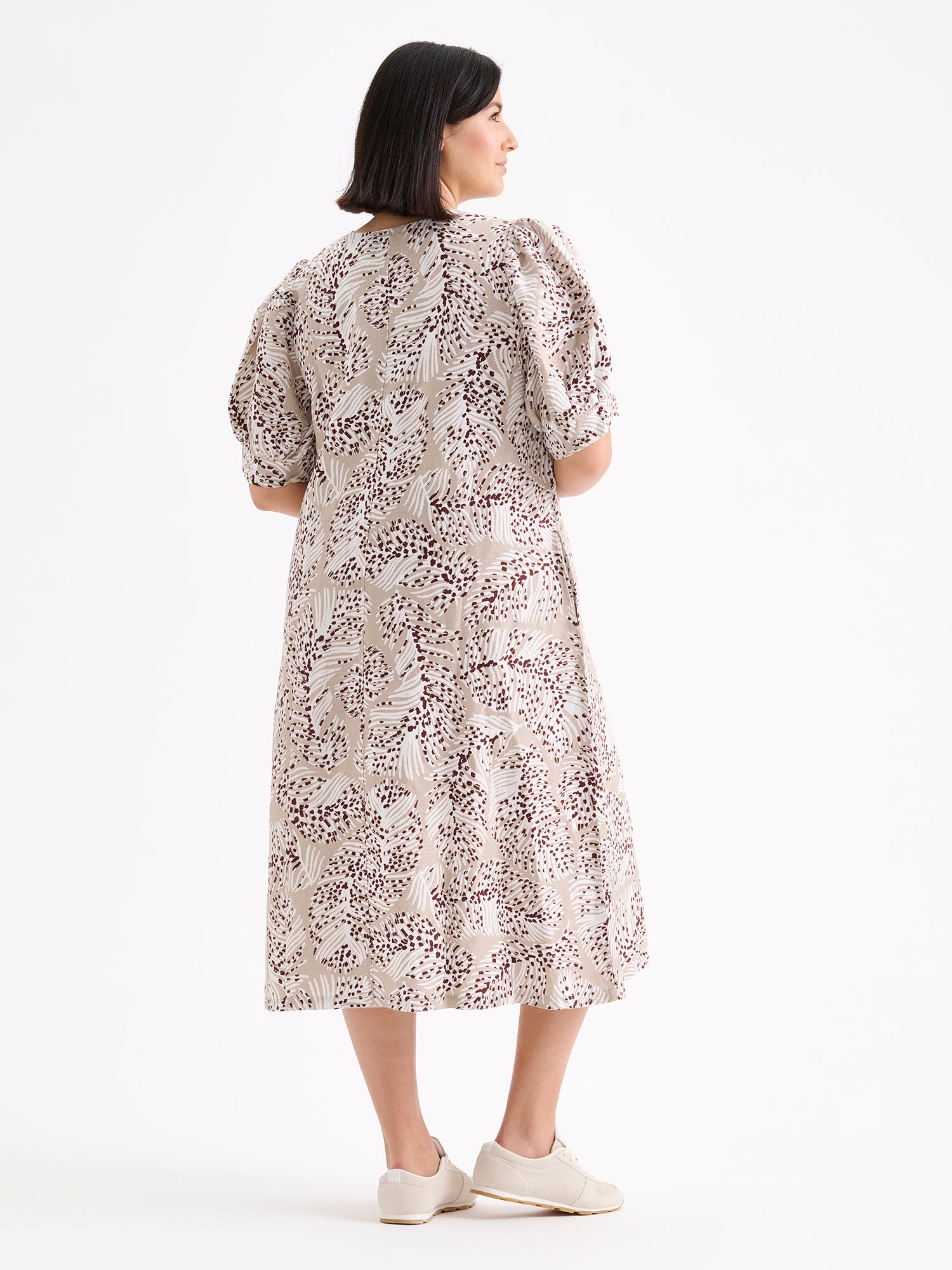 Nanso women's midi Hilde dress in a stylish and delicate beige print on a model with sneakers, from the backside