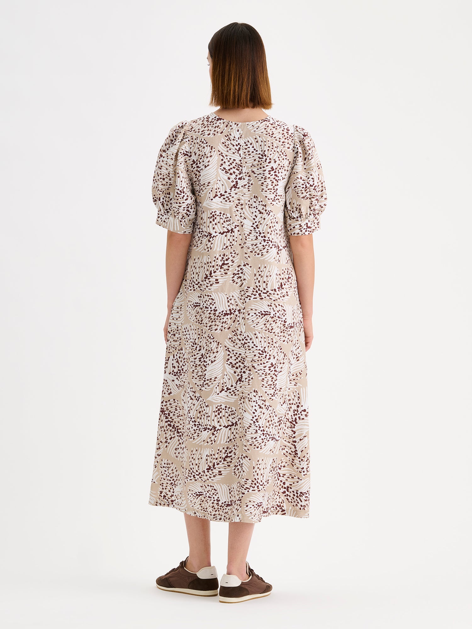 Nanso women's midi Hilde dress in a stylish and delicate beige print on a model with sneakers