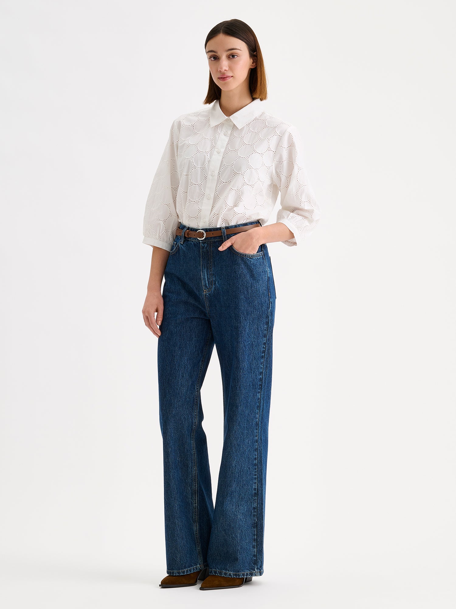 nanso women's stylish white Siiri blouse for women, featuring beautiful embroidered fabric, classic collar, buttons and 3/4 sleeves, on a model with wide blue jeans