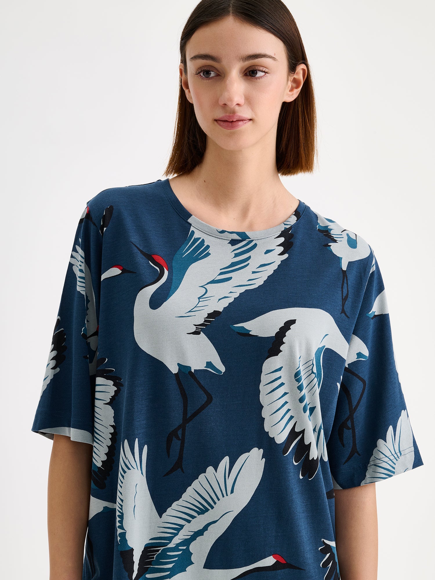Nanso women's long straight-cut Kurki nightgown captivates with its striking blue-toned pattern. This soft and comfortable classic is perfect for relaxed evenings at home. Pictured on a model, close-up.