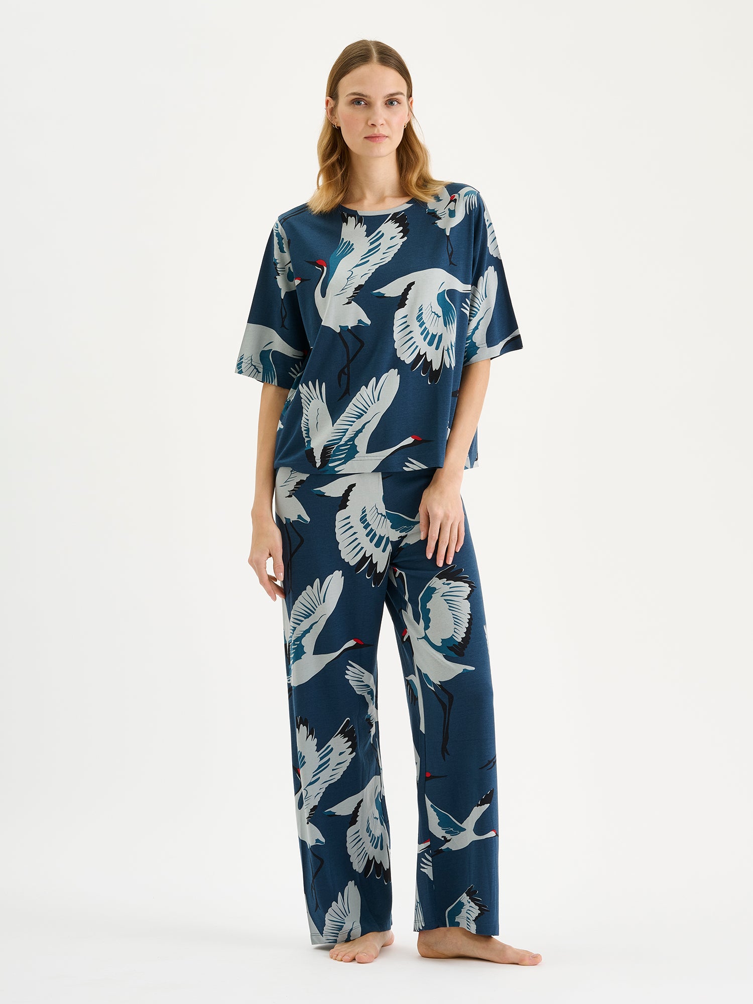 Nanso women's relaxed and loose-fitting Kurki lounge trousers with cropped legs and a charming blue-toned pattern on a model with a matching t-shirt.