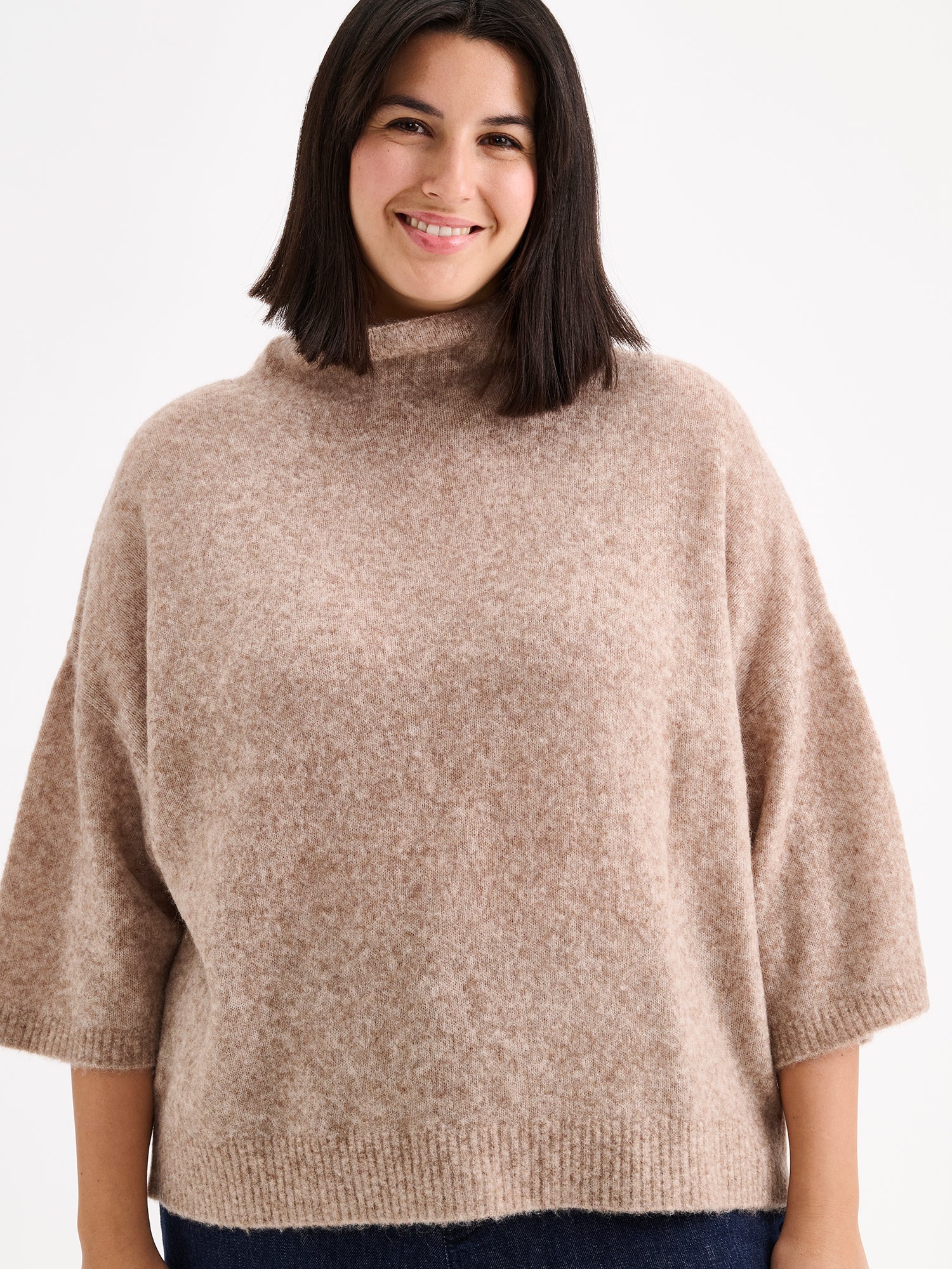 Nanso women's relaxed Alina knit sweater with a high neckline on a model with blue jeans