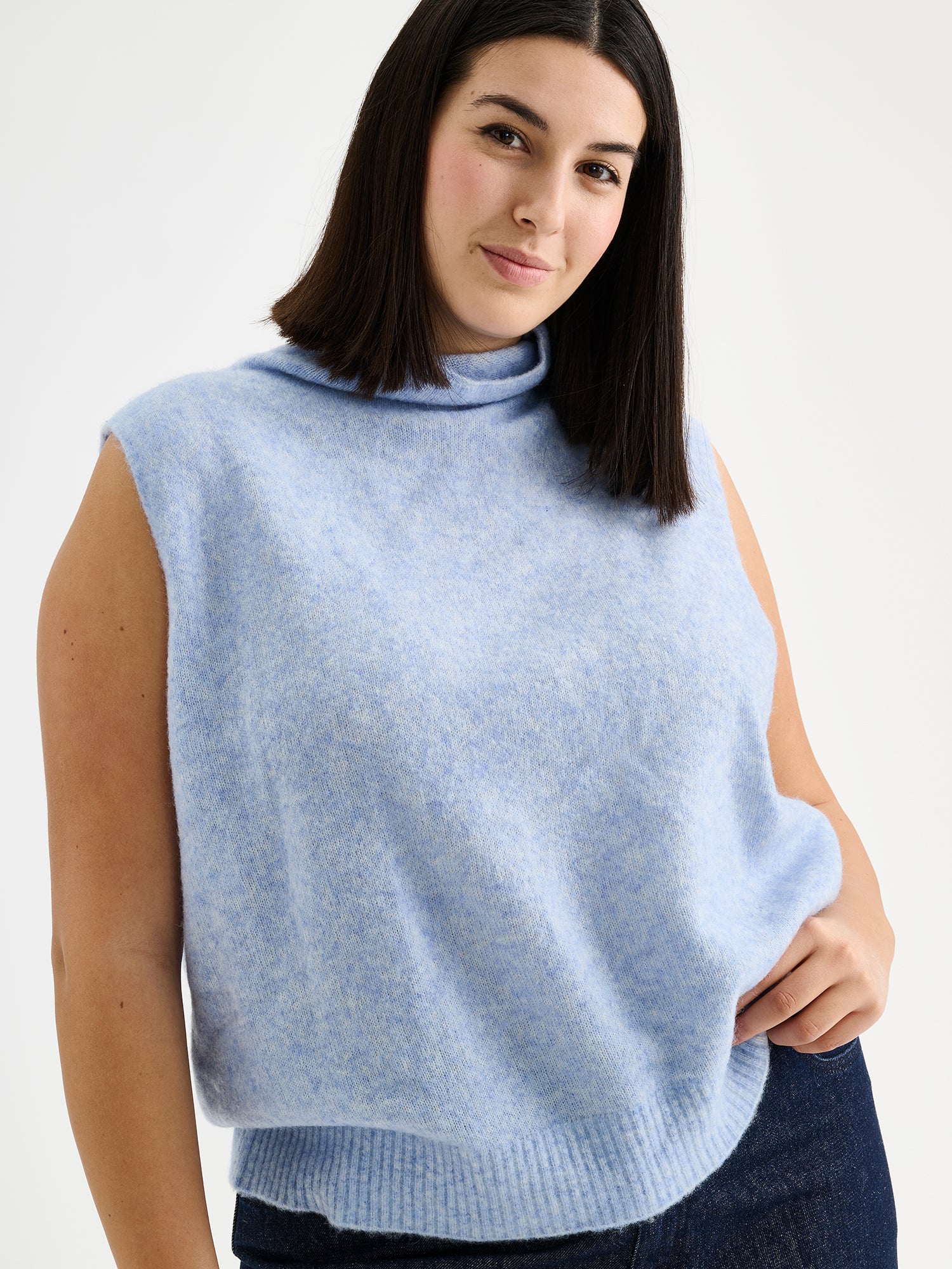 Nanso women's relaxed and wonderfully lightweight Alina knit vest with a high neckline on a model with blue jeans and sneakers