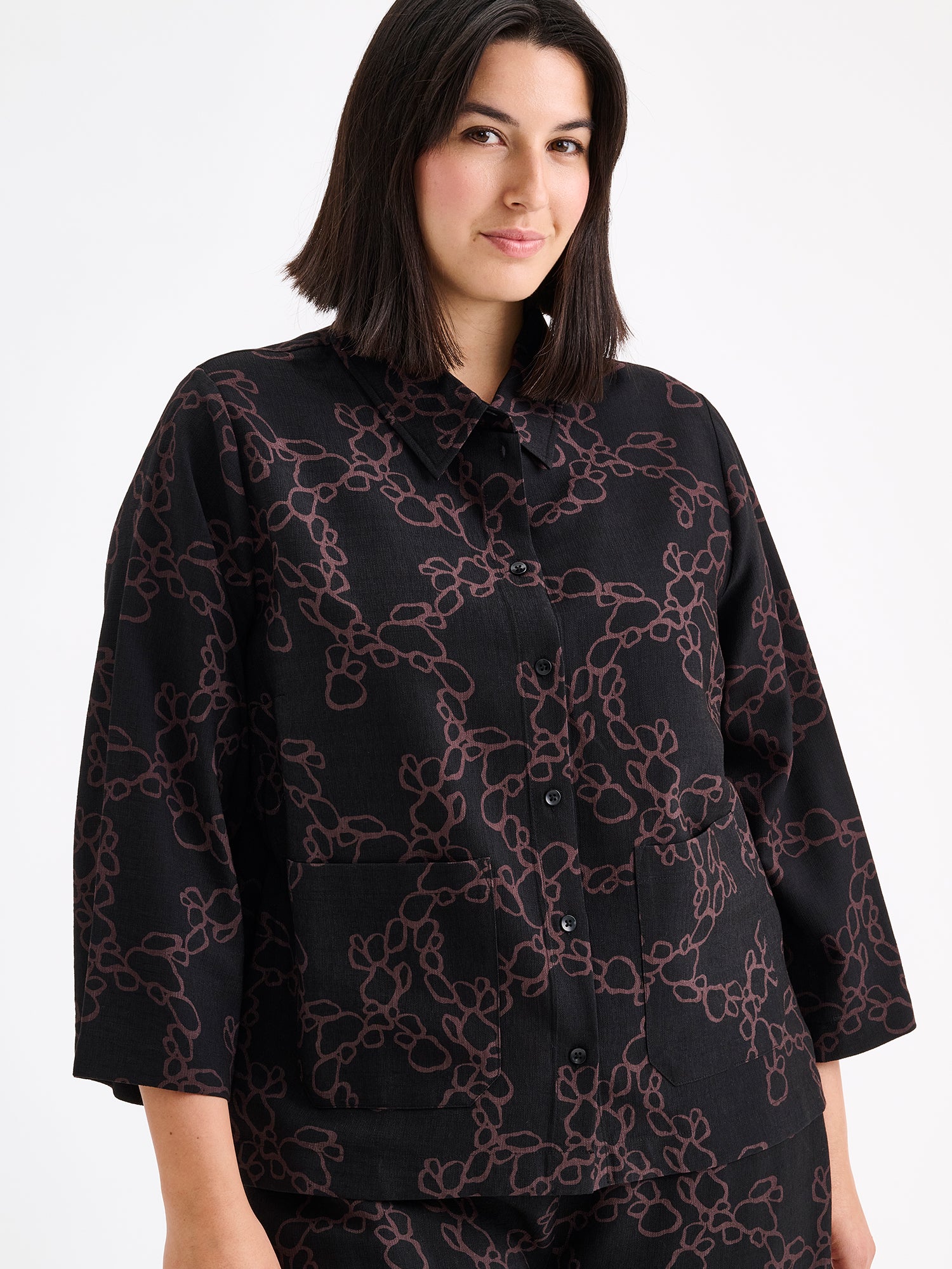 Women's patterned black and brown KIDE shirt and wide trousers on a model