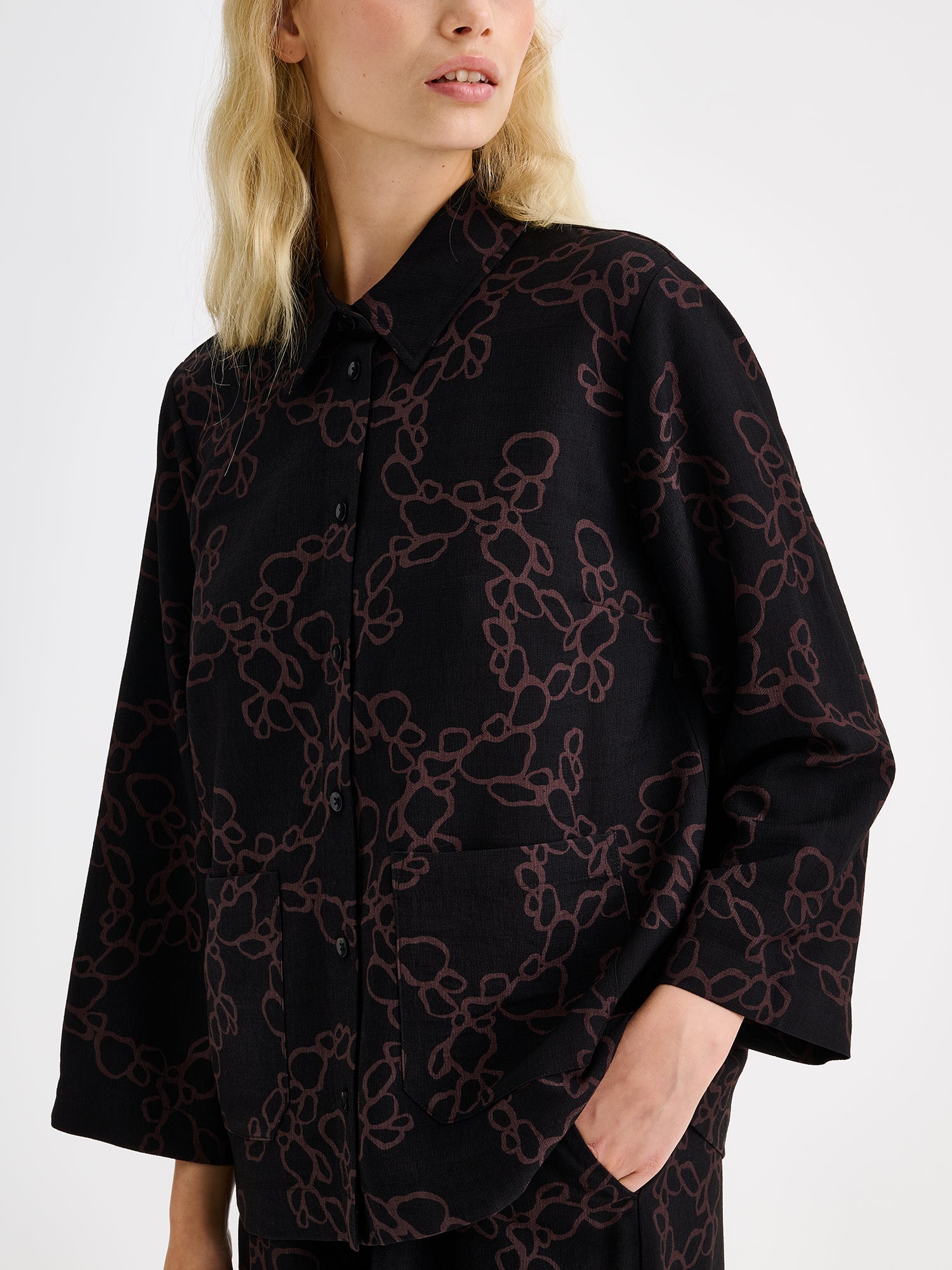 Women's patterned black and brown KIDE shirt and wide trousers on a model