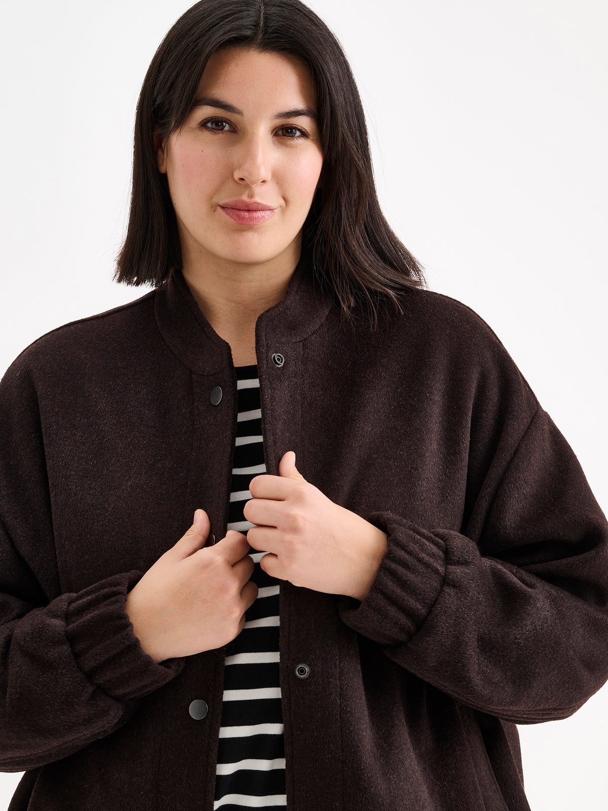 Nanso women's Tove wool bomber jacket in a rich brown shade combines the relaxed look of a bomber jacket with the timeless elegance of wool, on a model close-up.