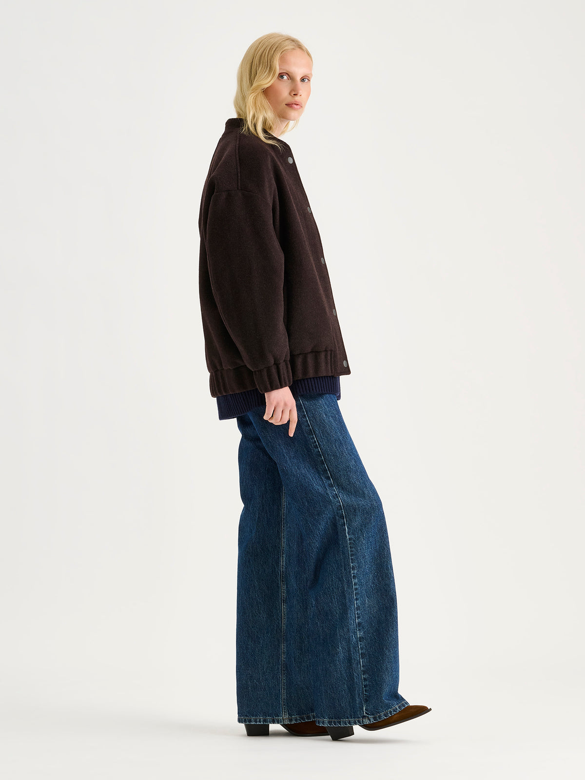 Nanso women's Tove wool bomber jacket in a rich brown shade combines the relaxed look of a bomber jacket with the timeless elegance of wool, on a model.