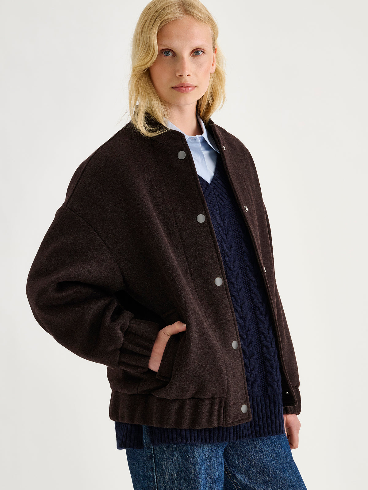 Nanso women's Tove wool bomber jacket in a rich brown shade combines the relaxed look of a bomber jacket with the timeless elegance of wool, on a model.