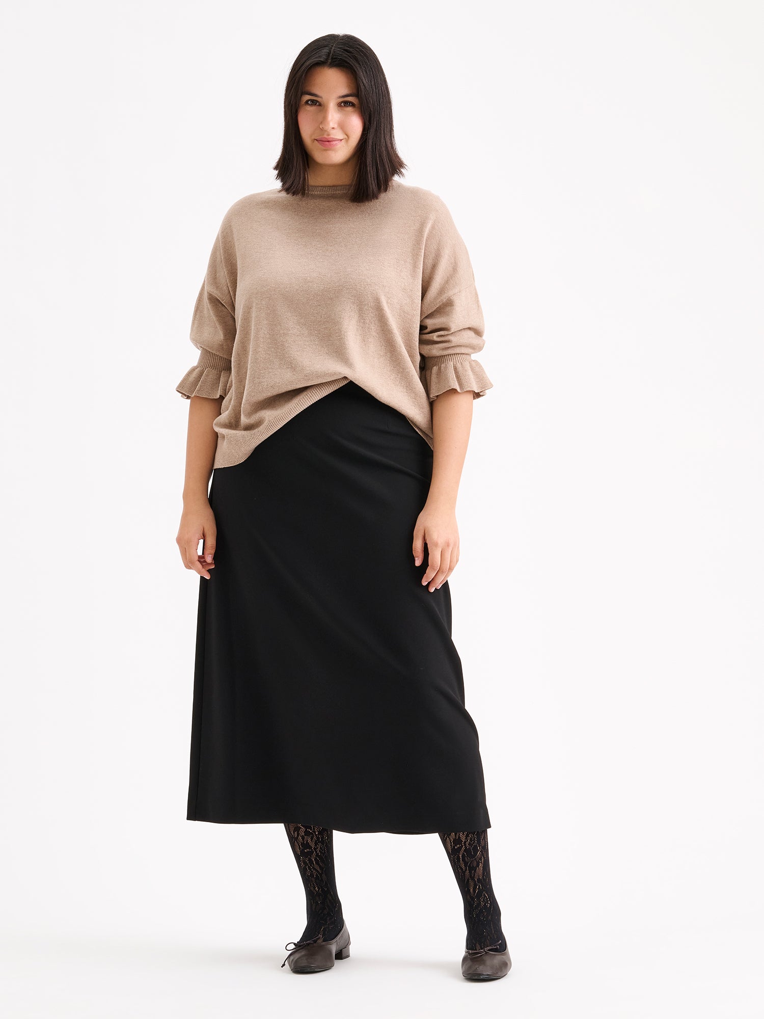 Nanso women's simply stylish and lightweight Villis Frilla knit jumper is charmingly finished with beautiful frill details at the cuffs, pictured on a model with a black skirt