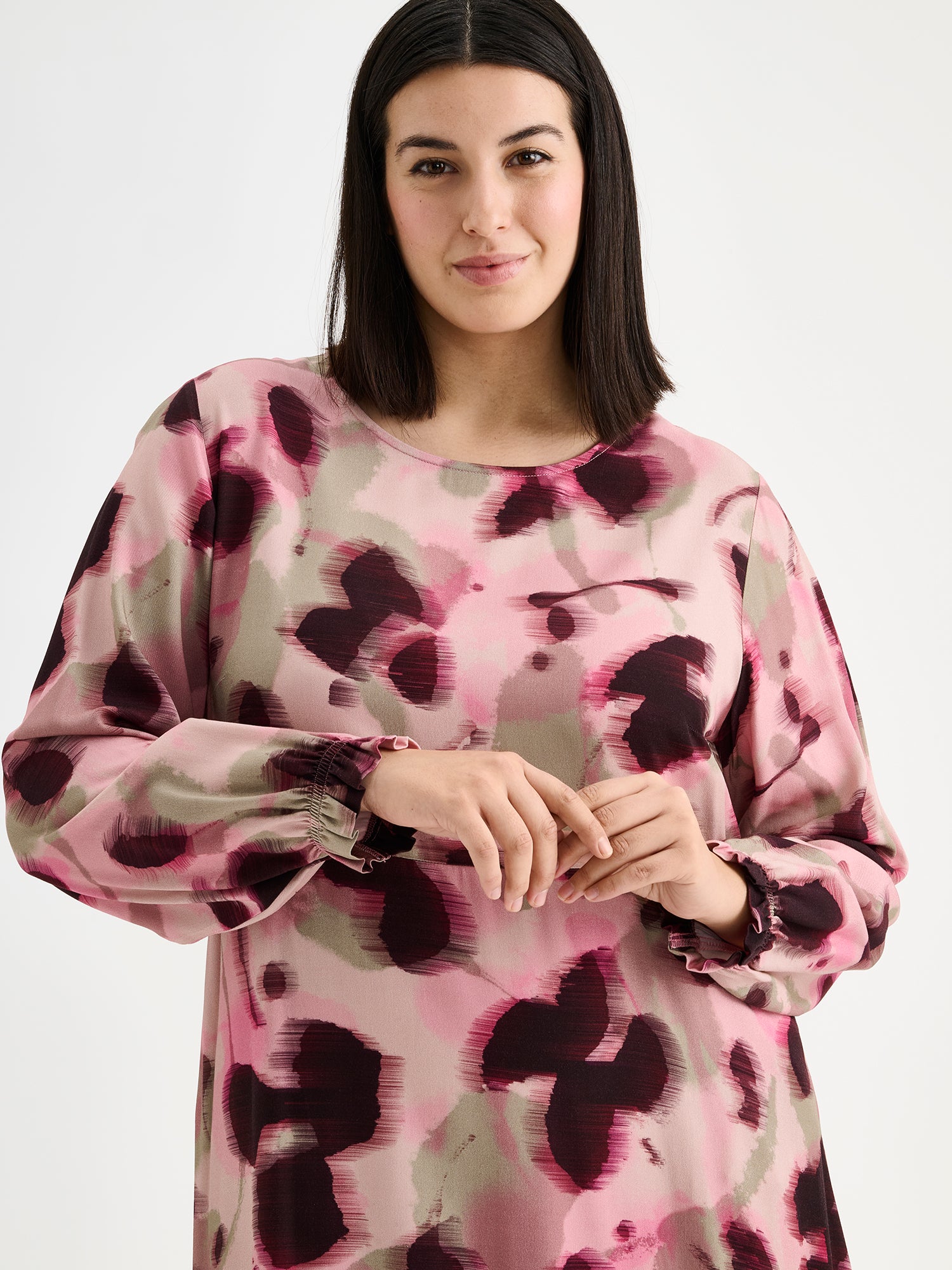 Nanso women's feminine and eye-catching Ruusu midi woven dress is adorned with a painterly print, on a model close-up