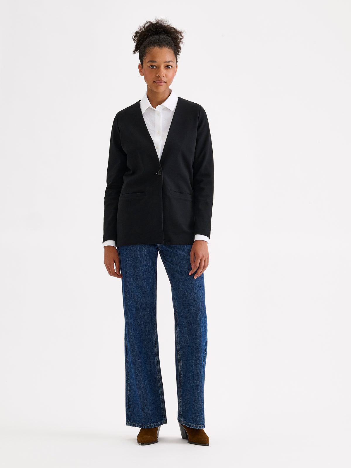 Nanso women's black collarless Nerea jersey blazer on a model with a white button-up shirt and jeans. | S - 177cm