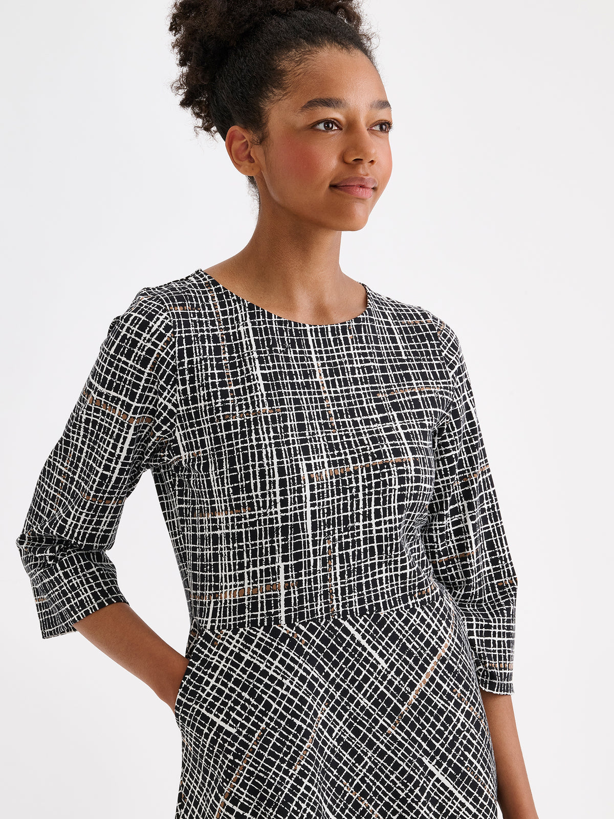 Nanso women's Ristikko jersey dress features a stylish graphic black-and-white check pattern, picture on a model close-up.