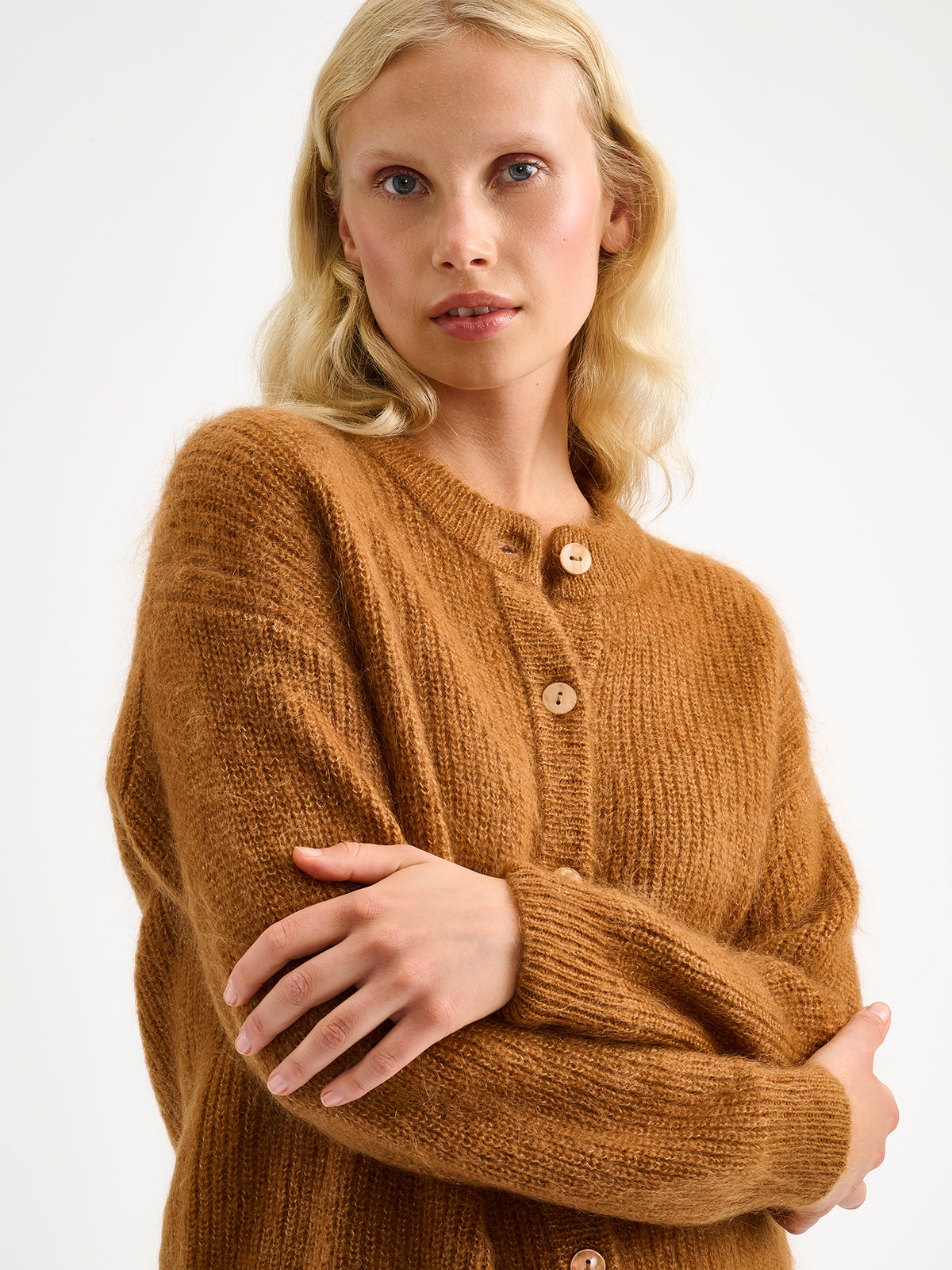 Nanso women's wonderfully warm and luxurious Sumi cardigan enchants with its rich brown hue and beautifully fluffy texture. On a model close-up.