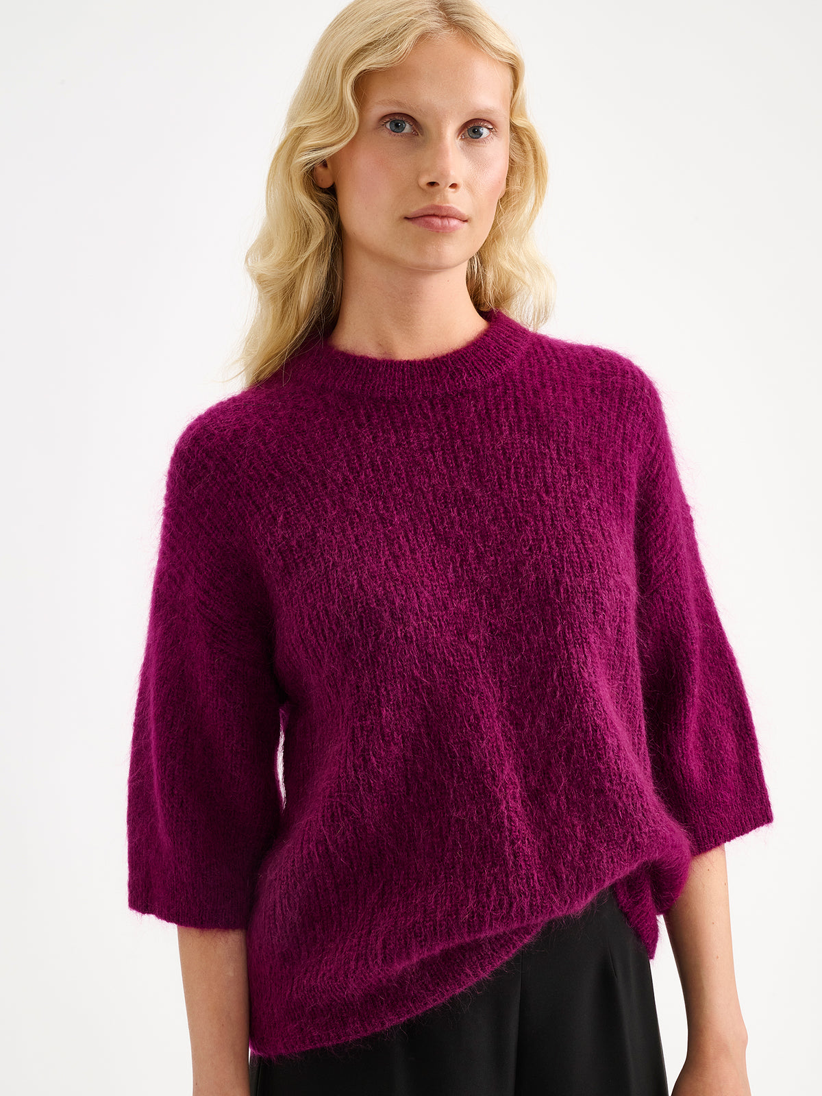 Nanso women's wonderfully warm and luxurious Sumi knitted sweater in vibrant violet and beautifully fluffy texture, on a model with black trousers.