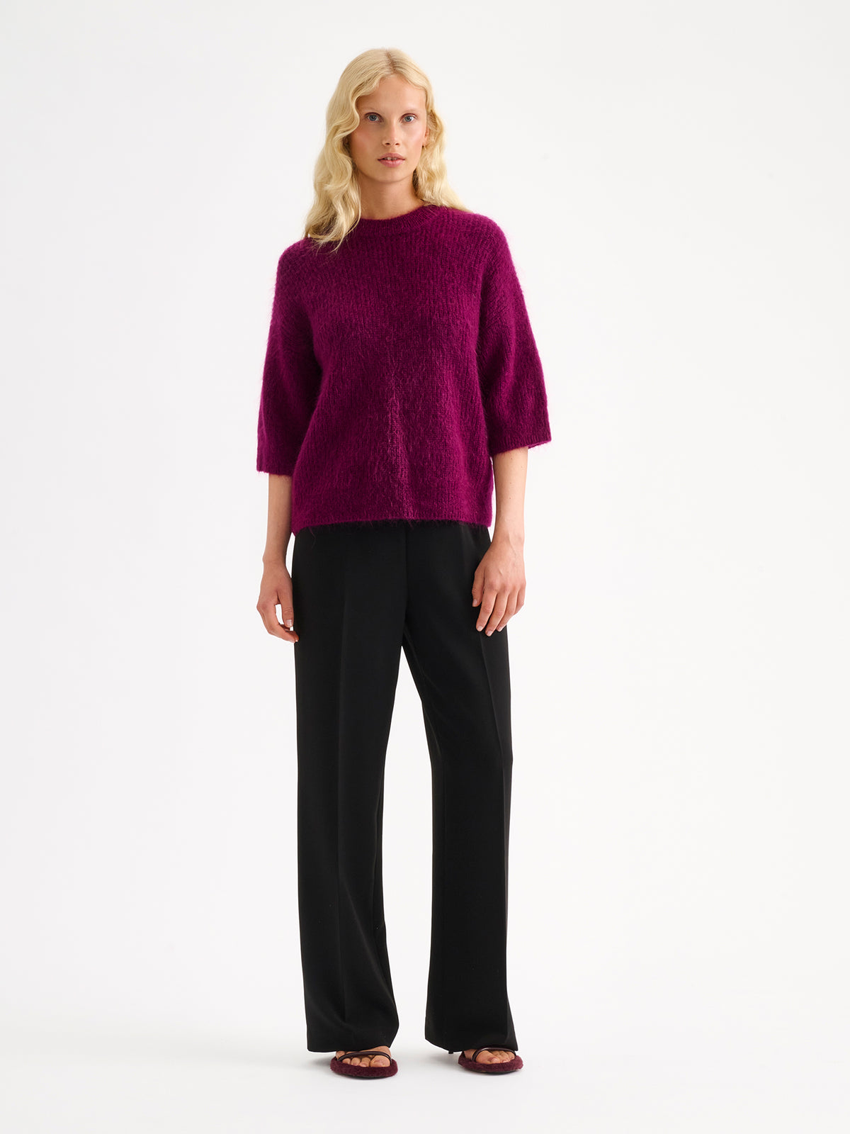 Nanso women's wonderfully warm and luxurious Sumi knitted sweater in vibrant violet and beautifully fluffy texture, on a model with black trousers. | S - 174cm