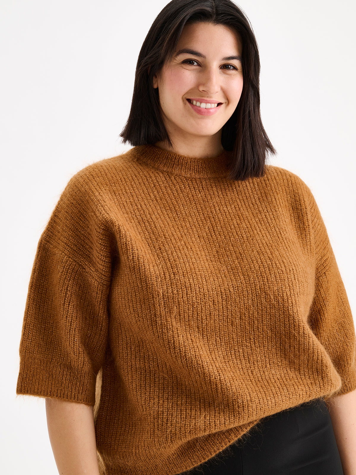 Nanso women's wonderfully warm and luxurious Sumi knitted sweater in rich brown and beautifully fluffy texture, on a model with black trousers.