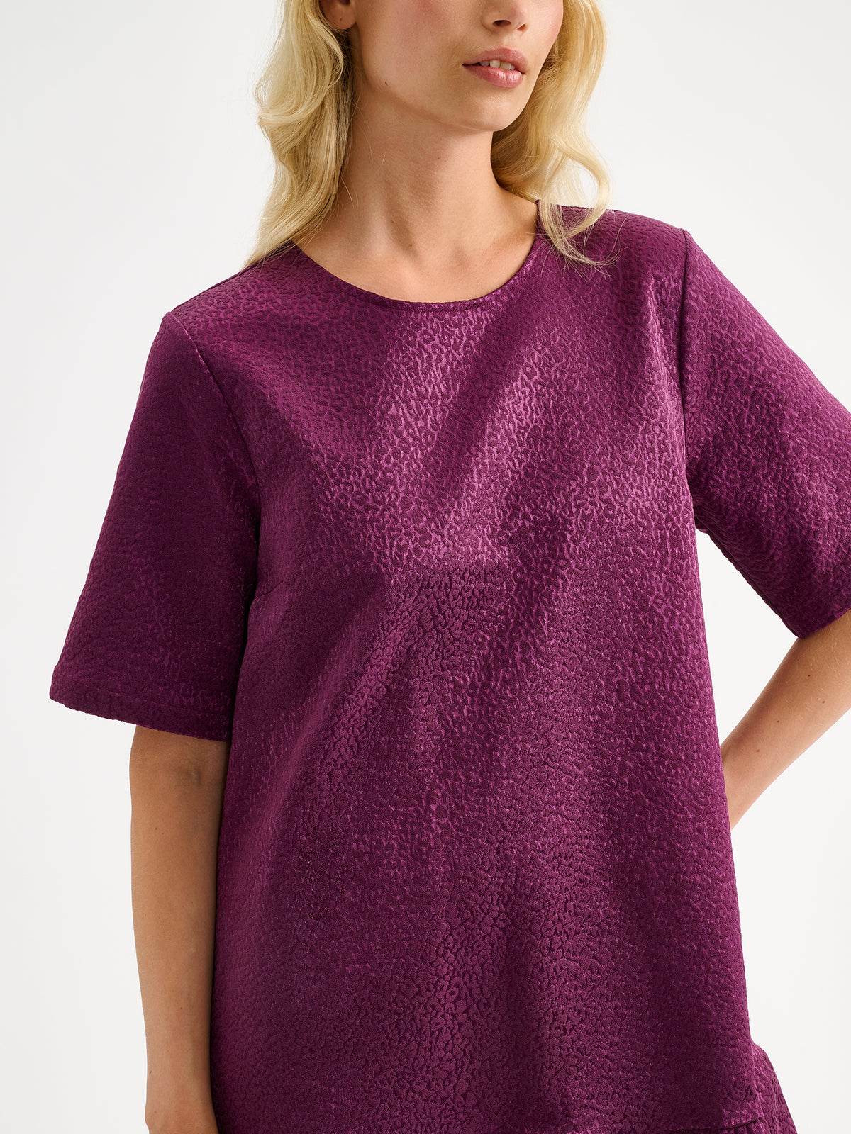 Nanso women's striking Leora dress captivates with its beautiful fabric, combining a festive sheen with a rich textured surface, pictured on a model close-up.