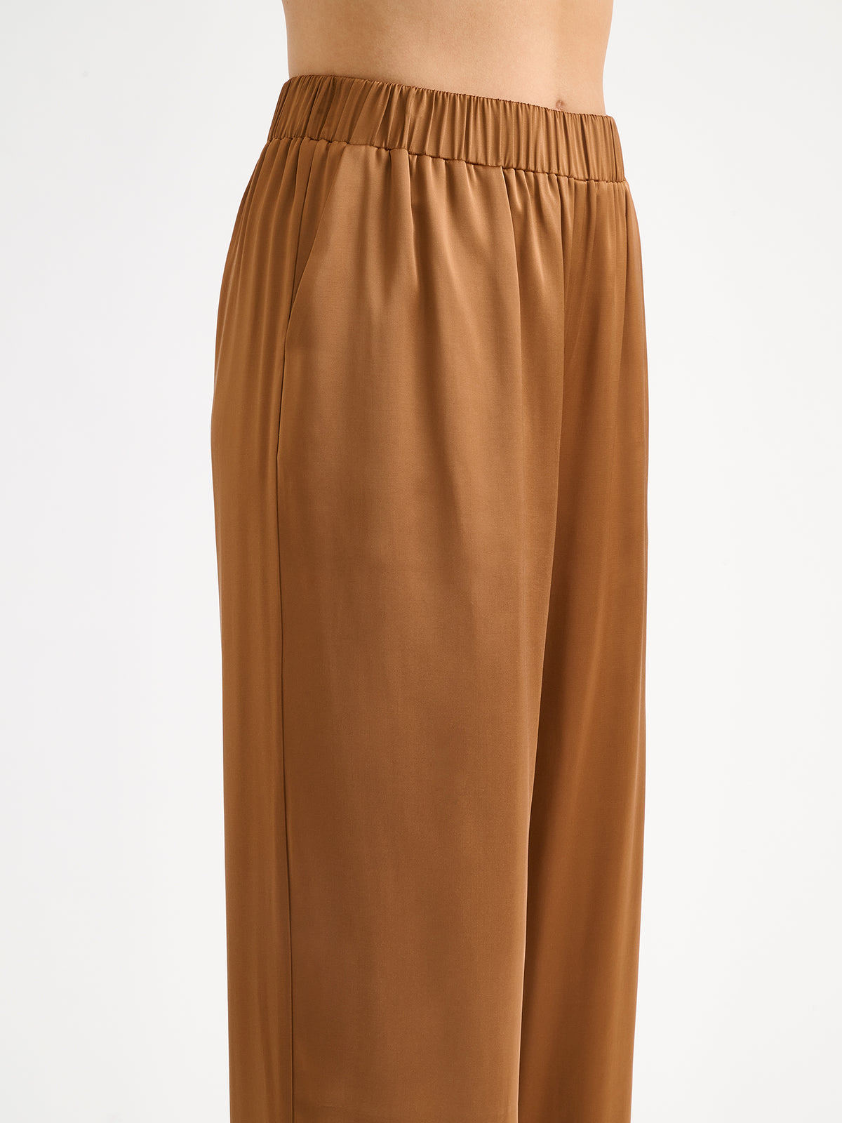 Nanso women's elegant Silva satin trousers captivate with their rich brown shade and beautifully flowing satin fabric. On a model close-up.