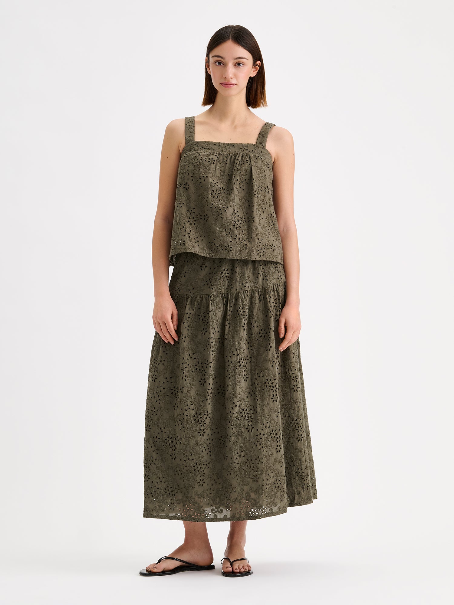 Nanso women's beautiful olive green Odette top for women, crafted from delicate lace-like Broderie anglaise style cotton fabric, on a model with a matching skirt.