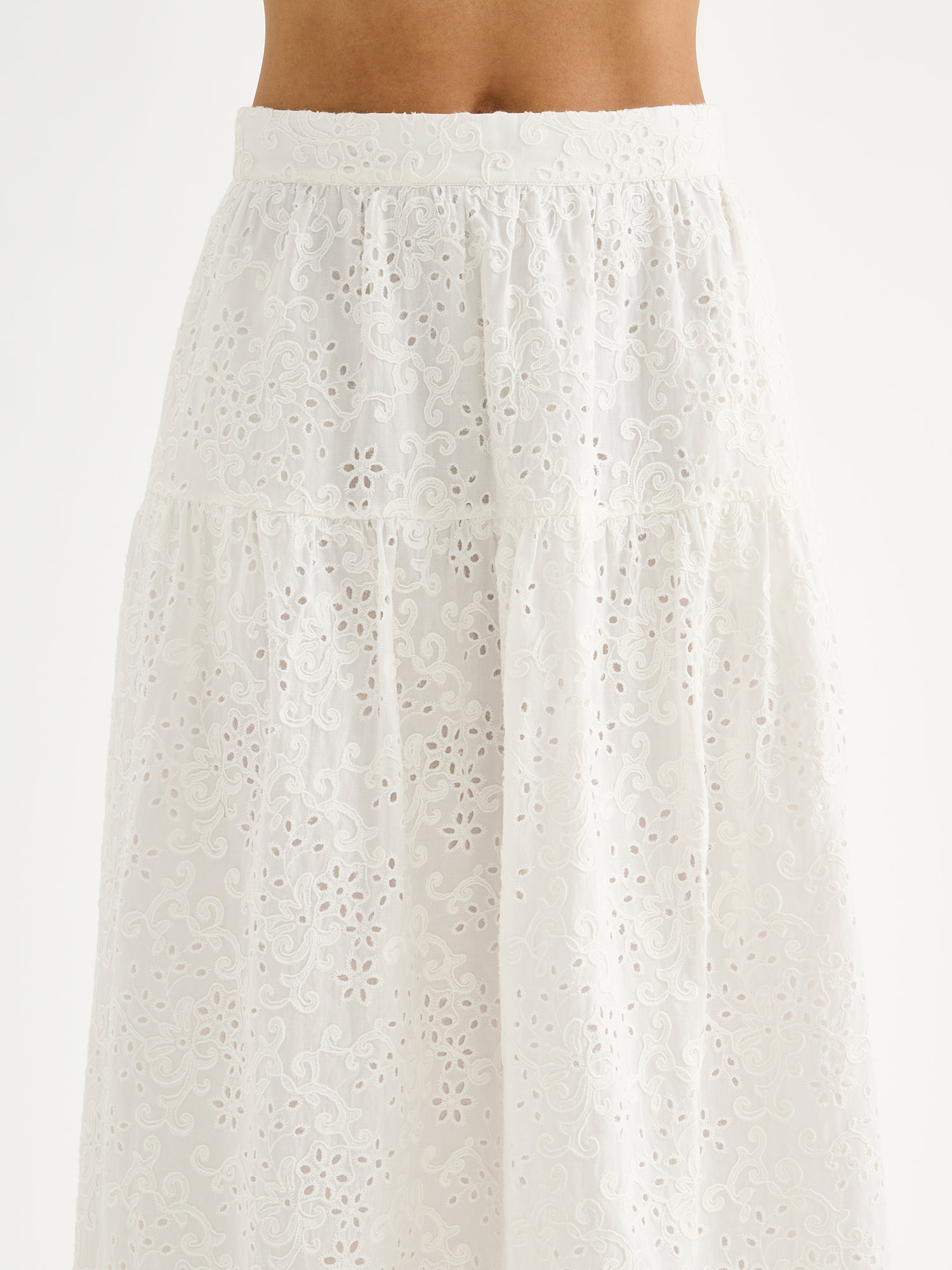 Nanso women's Odette skirt is a beautiful maxi-length skirt with a flowing silhouette, crafted from soft white cotton fabric featuring delicate broderie anglaise detailing, on a model close-up.