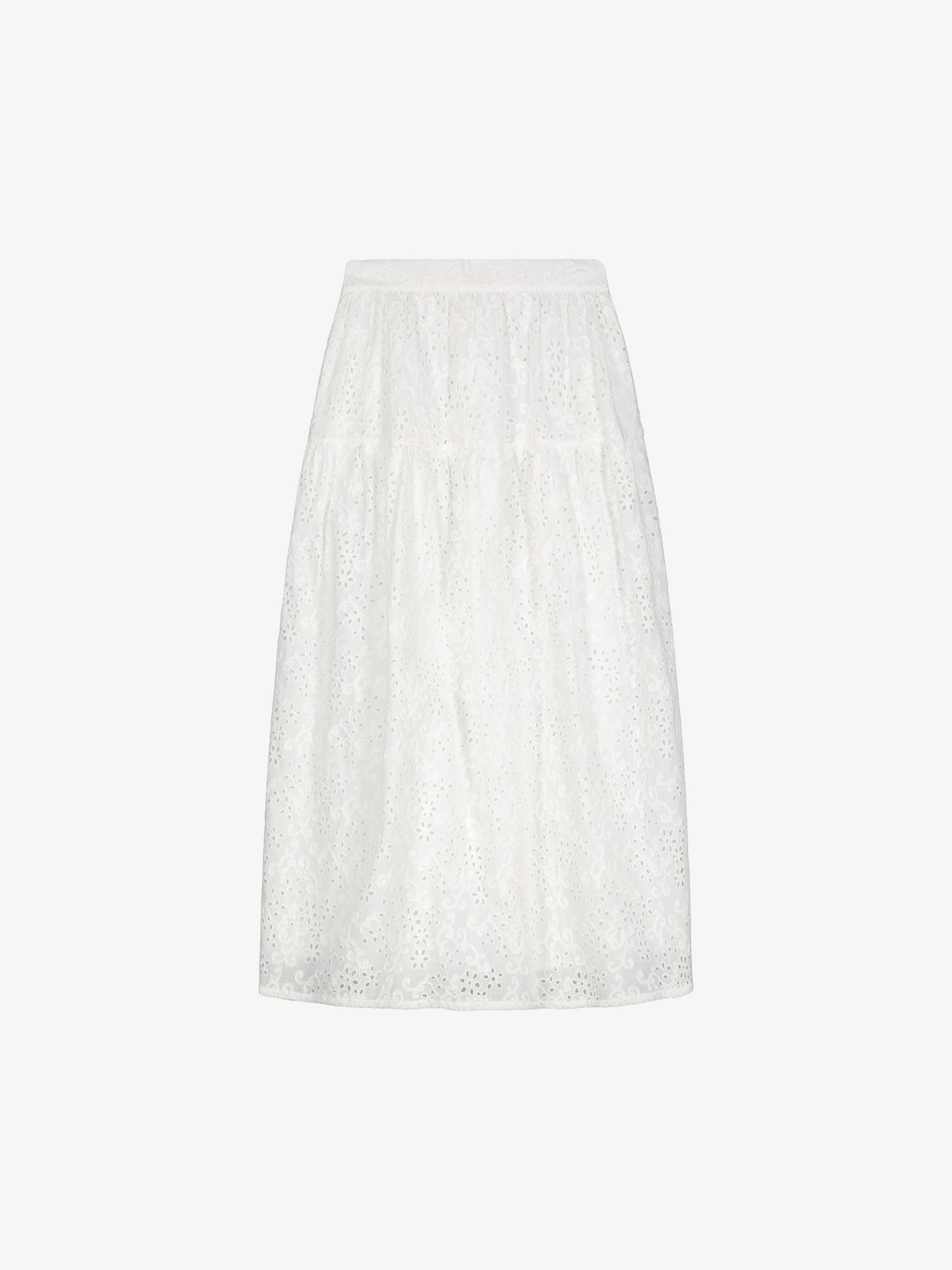 Nanso women's Odette skirt is a beautiful maxi-length skirt with a flowing silhouette, crafted from soft white cotton fabric featuring delicate broderie anglaise detailing, in a product picture.