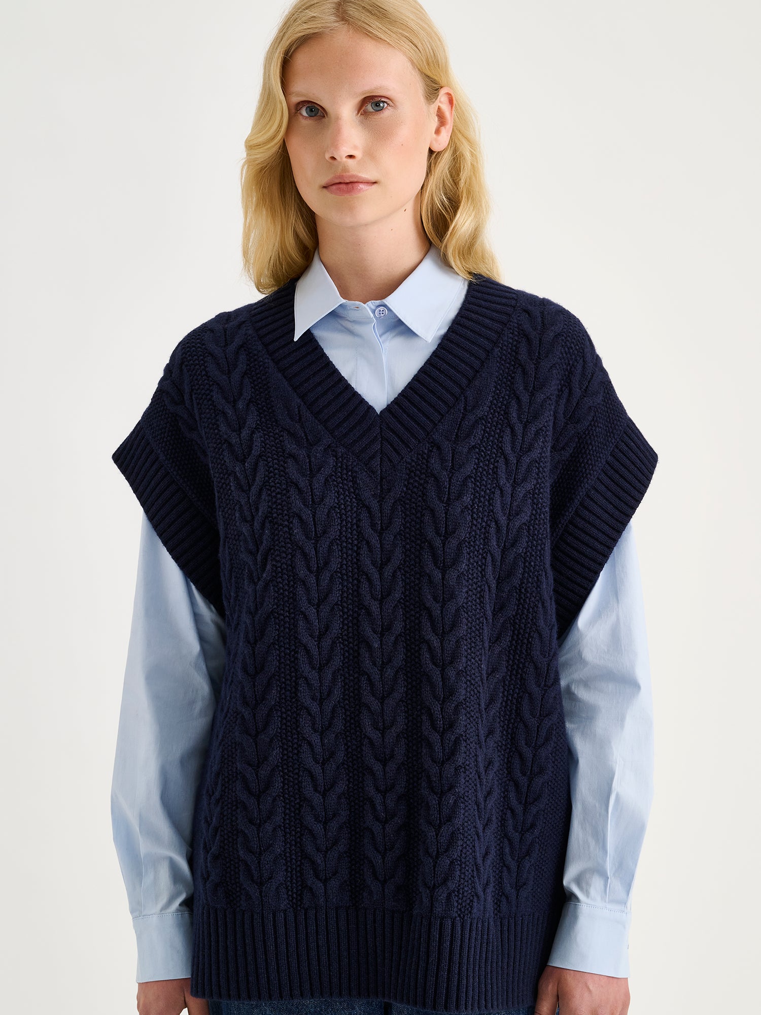 Nanso women's relaxed and generously cut Palmikot -knit vest on a blonde model with collared button up shirt