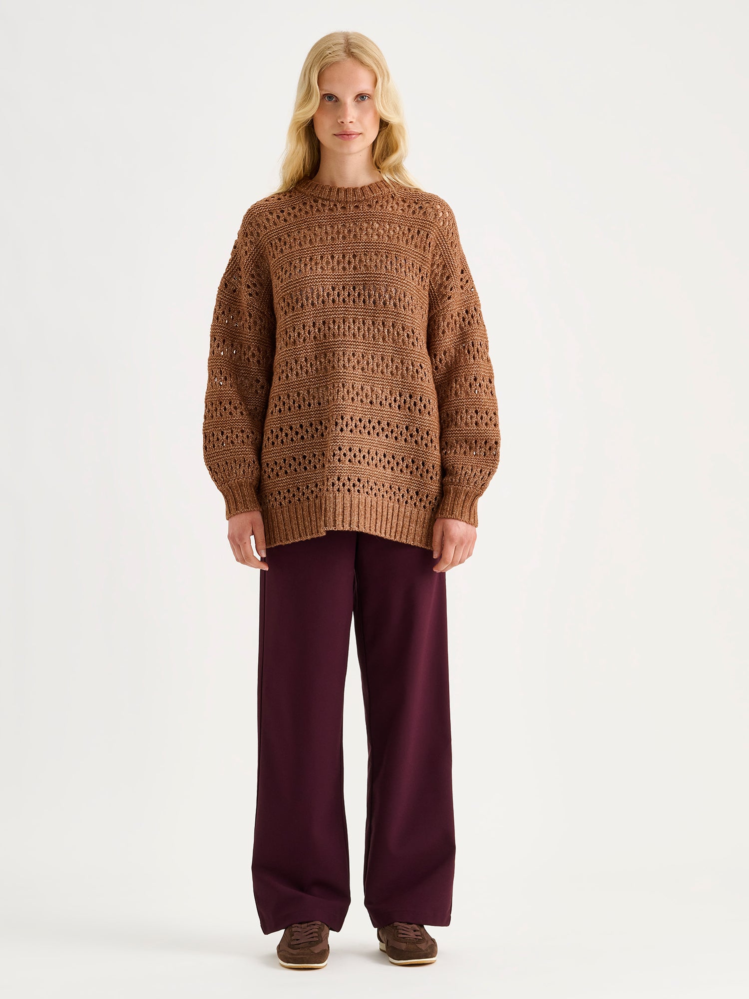 Nanso Women's Jonna wine red trousers on a blonde model with a brown sweater.