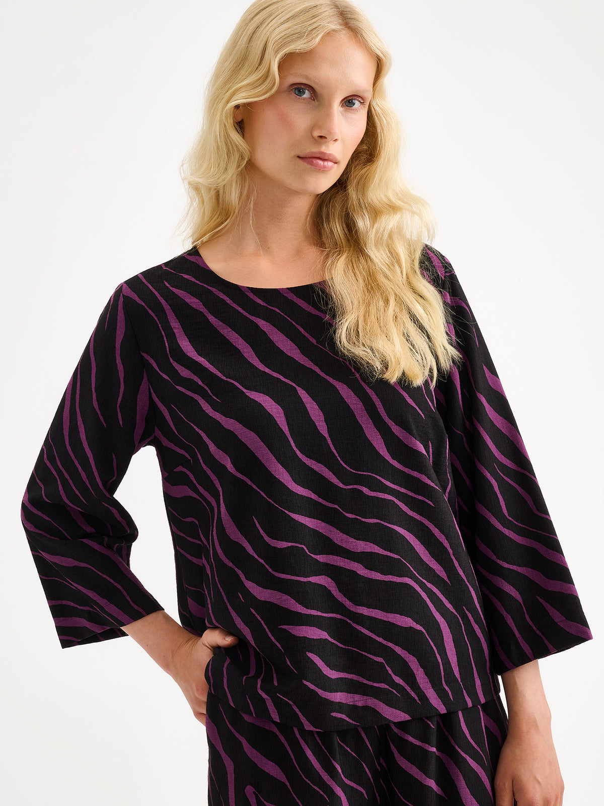 Nanso women's stylish Sypressi blouse showcases a striking print in black and violet, pictured on a model with matching trousers close-up. | 36 - 174cm