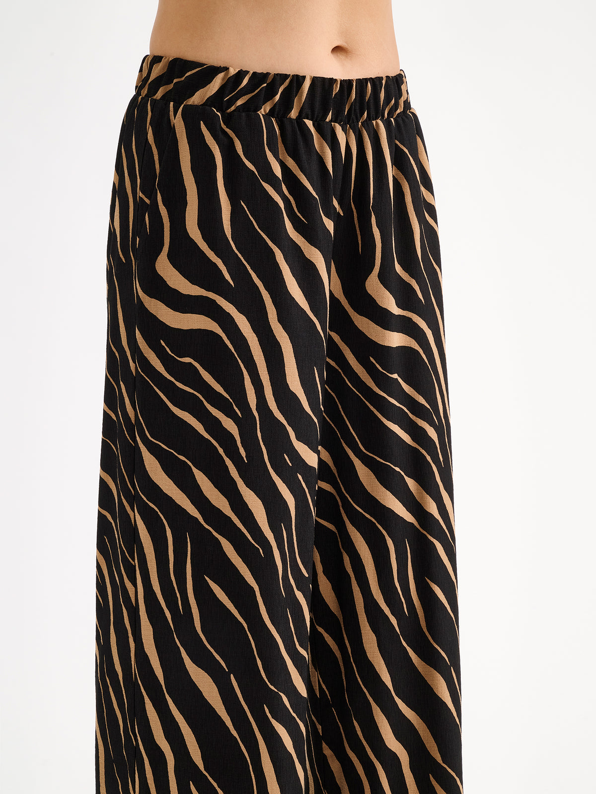 Nanso women's striking Sypressi trousers combine beautifully draping fabric with a trendy wide-leg silhouette. On a model close-up.