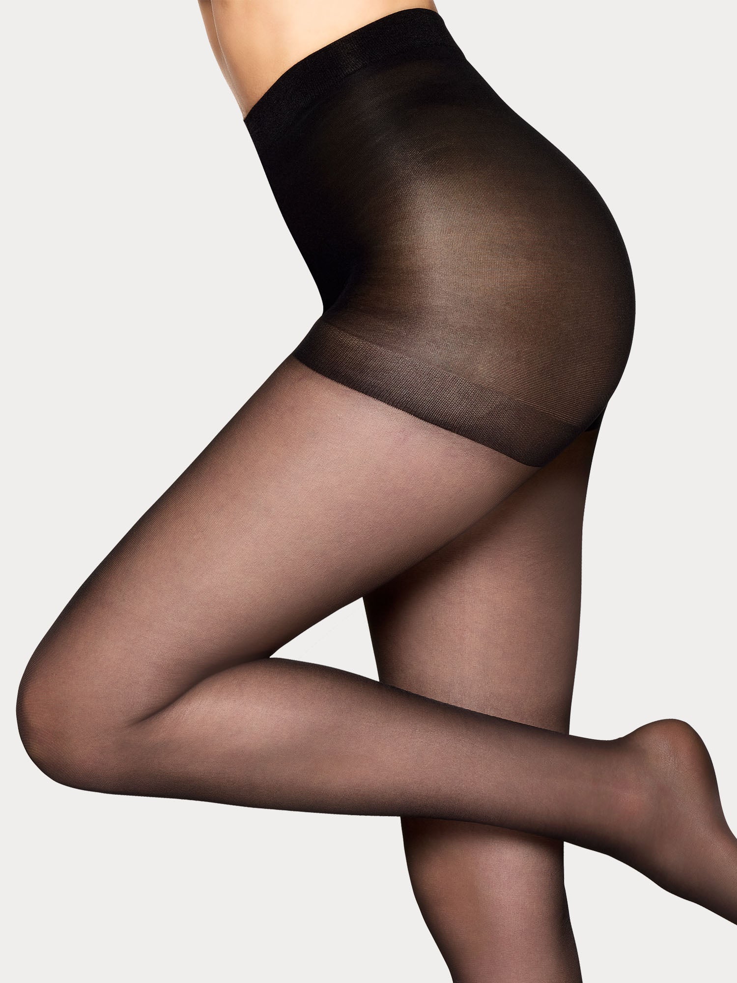 Vogue women's 20 den shiny tights in black feature a Control Top panty, flat seam, and gusset with a panel for sizes 44-48, on model.